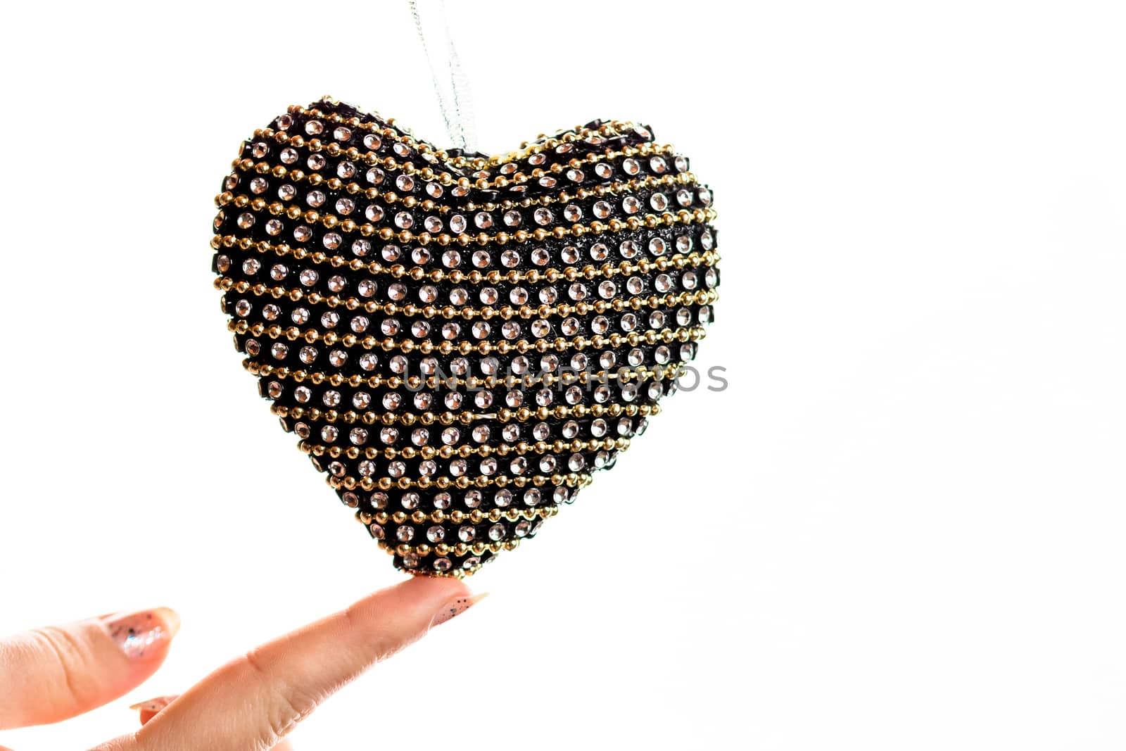 Hand holding heart shaped decoration isolated on white. by vladispas