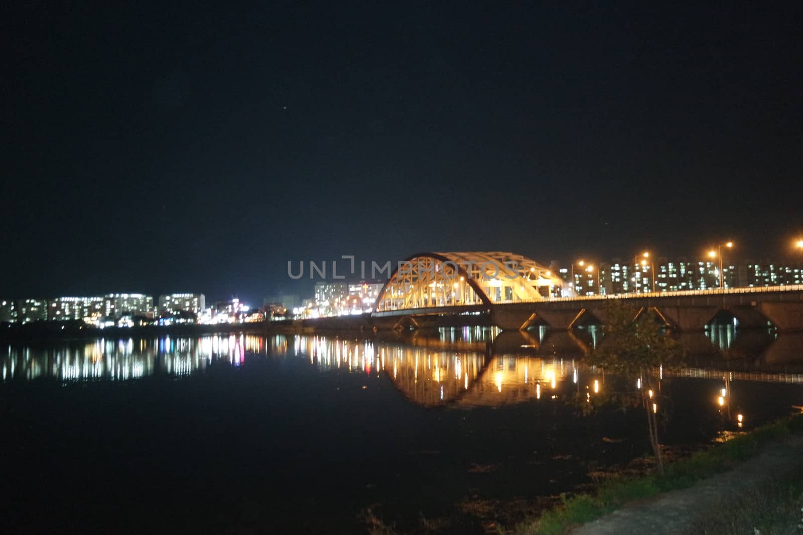 Night view of a beautiful scene of bridge over sea water in the evening time with colorful lights.