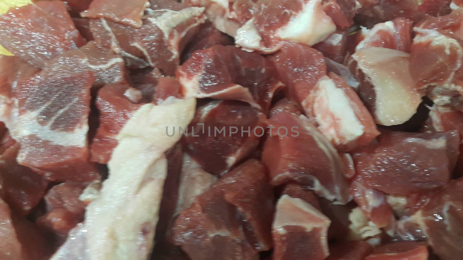 Close up view of fresh finely chopped meat cubes. Red meat small steaks with whitish meat fat.
