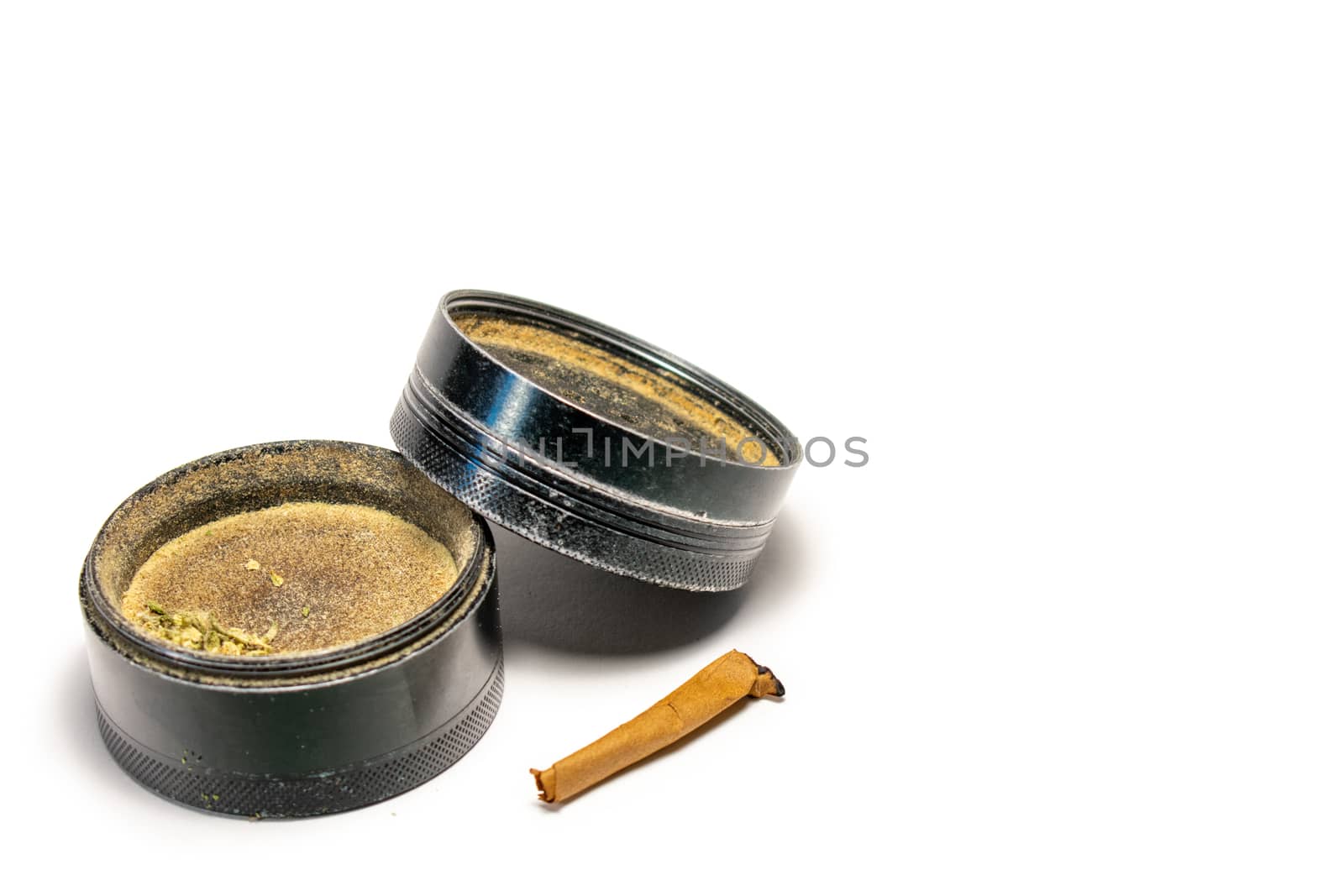 A Black Cannabis Grinder With the Lid Leaning On the Side With the End of a Smoked Cannabis Cigar