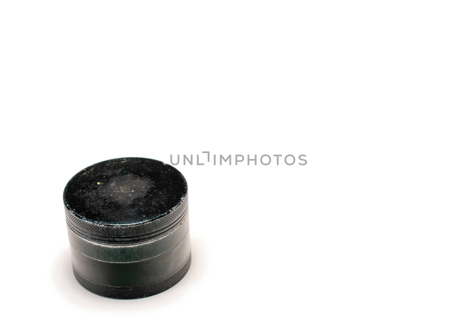 A Used Black Cannabis Grinder With the Lid On Top by bju12290