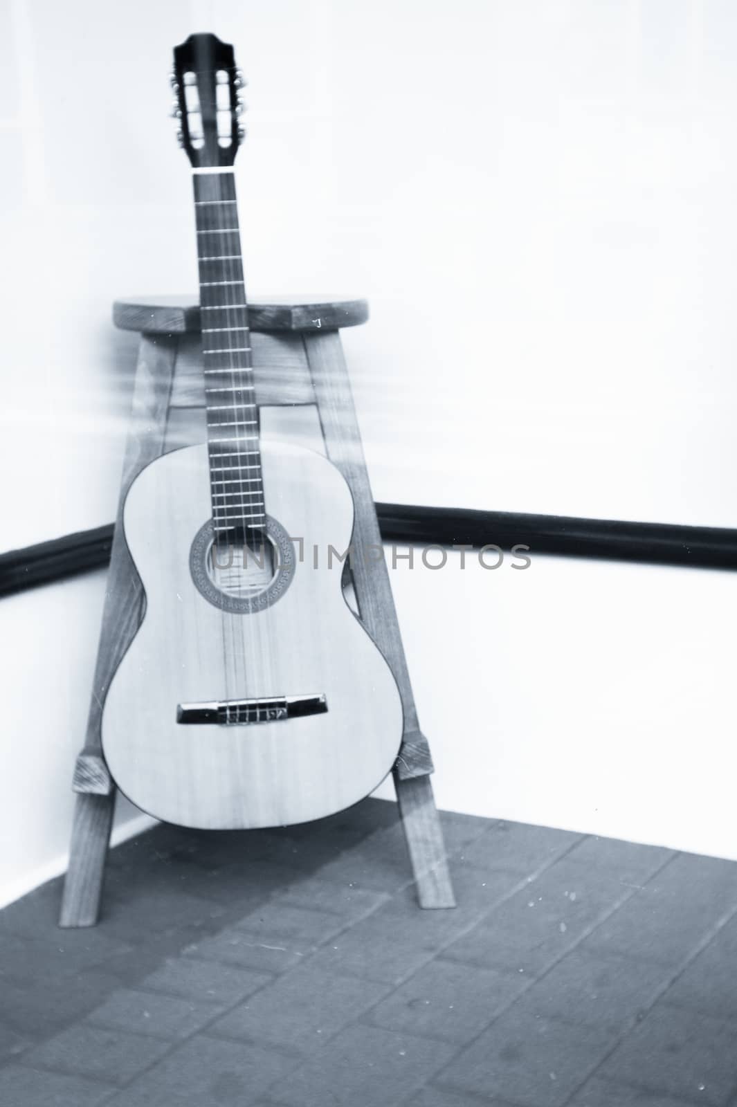Spanish guitar musical instrument perched on a tripod. No people