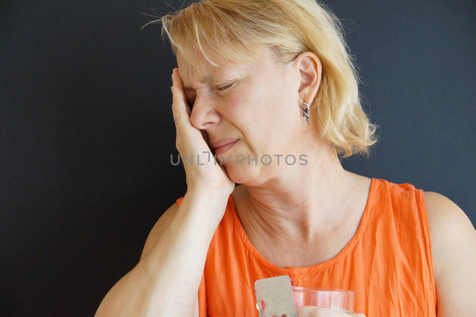 unhappy woman holding her head with her hand, portrait on black background by Annado