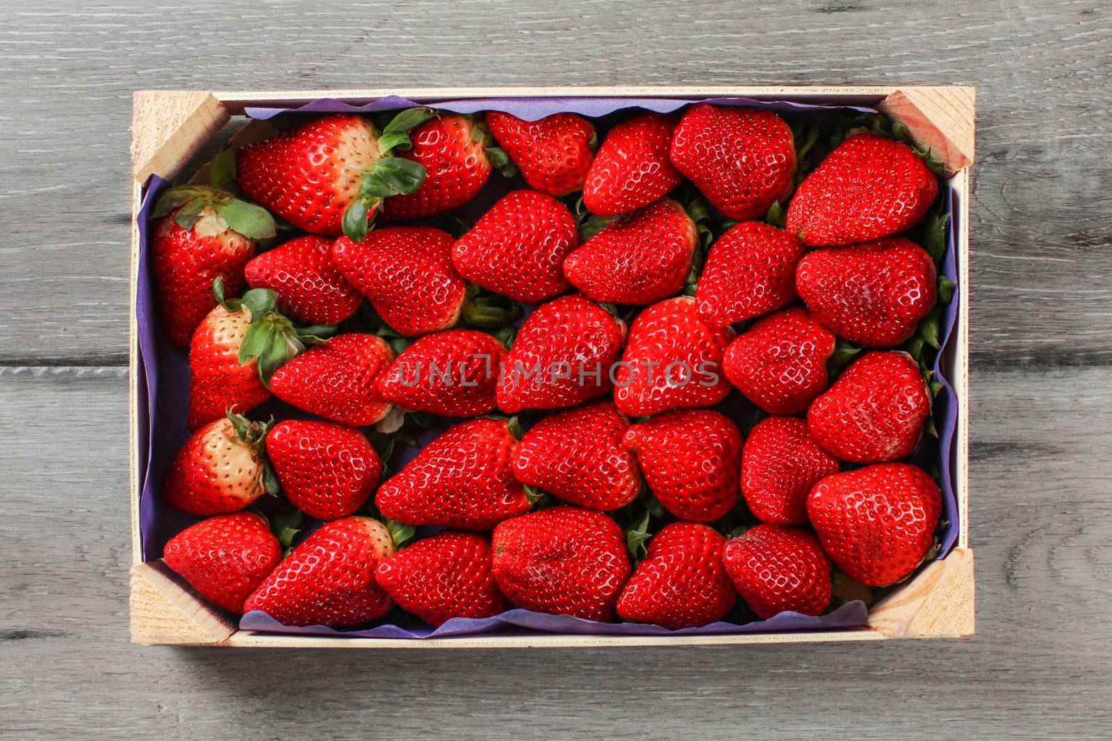 Table top view on small box of strawberries from supermarket pla by Ivanko