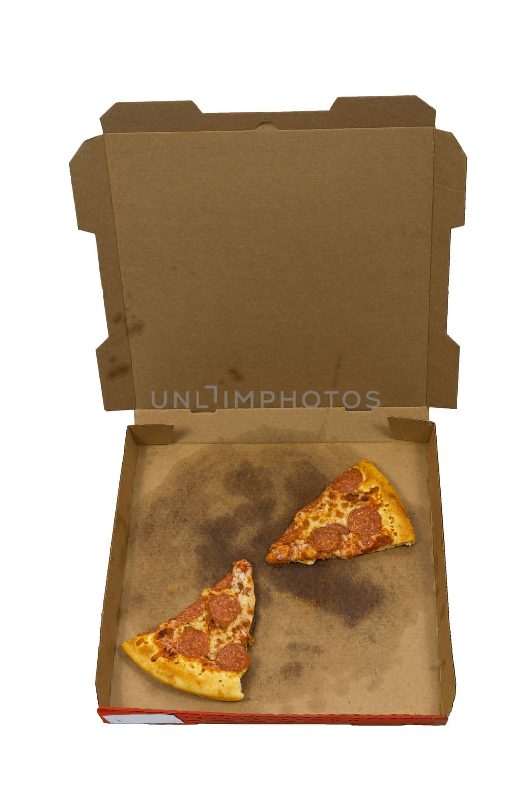 Vertical overhead shot of some slices of leftover pizza in a delivery box isolated on white background.