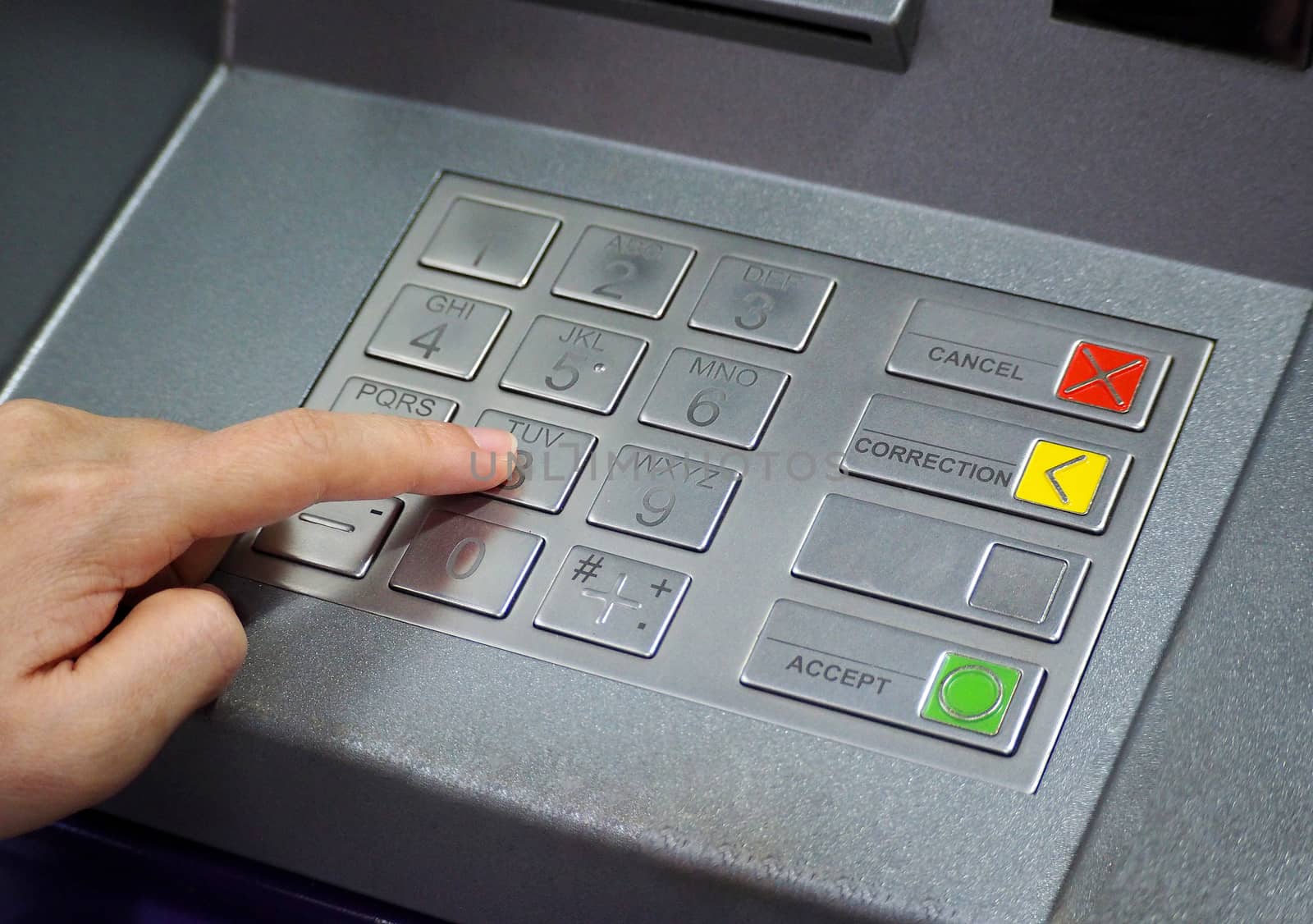 ATM pin button close-up and human hand index finger. by gnepphoto
