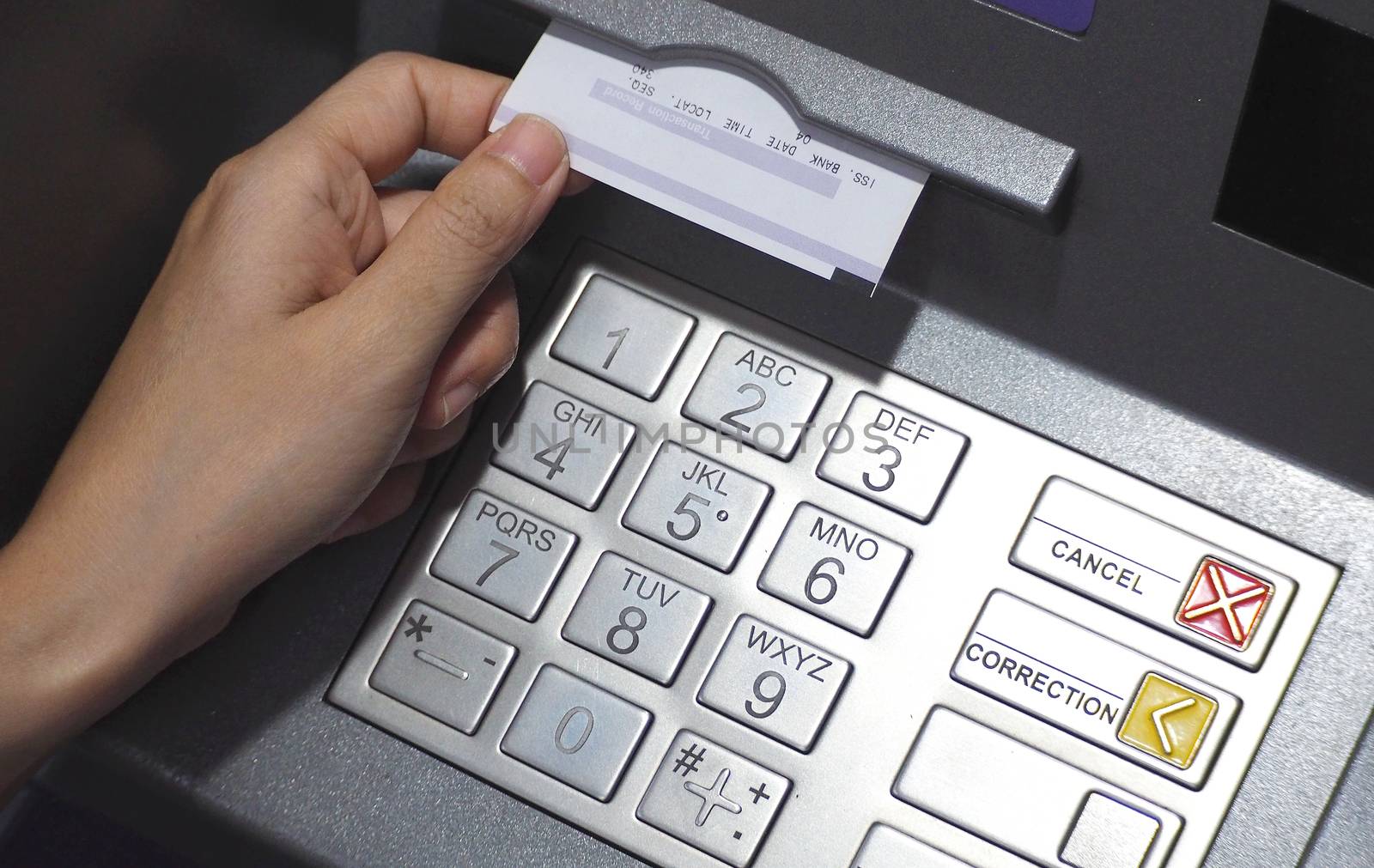 ATM button close-up and paper transaction. by gnepphoto