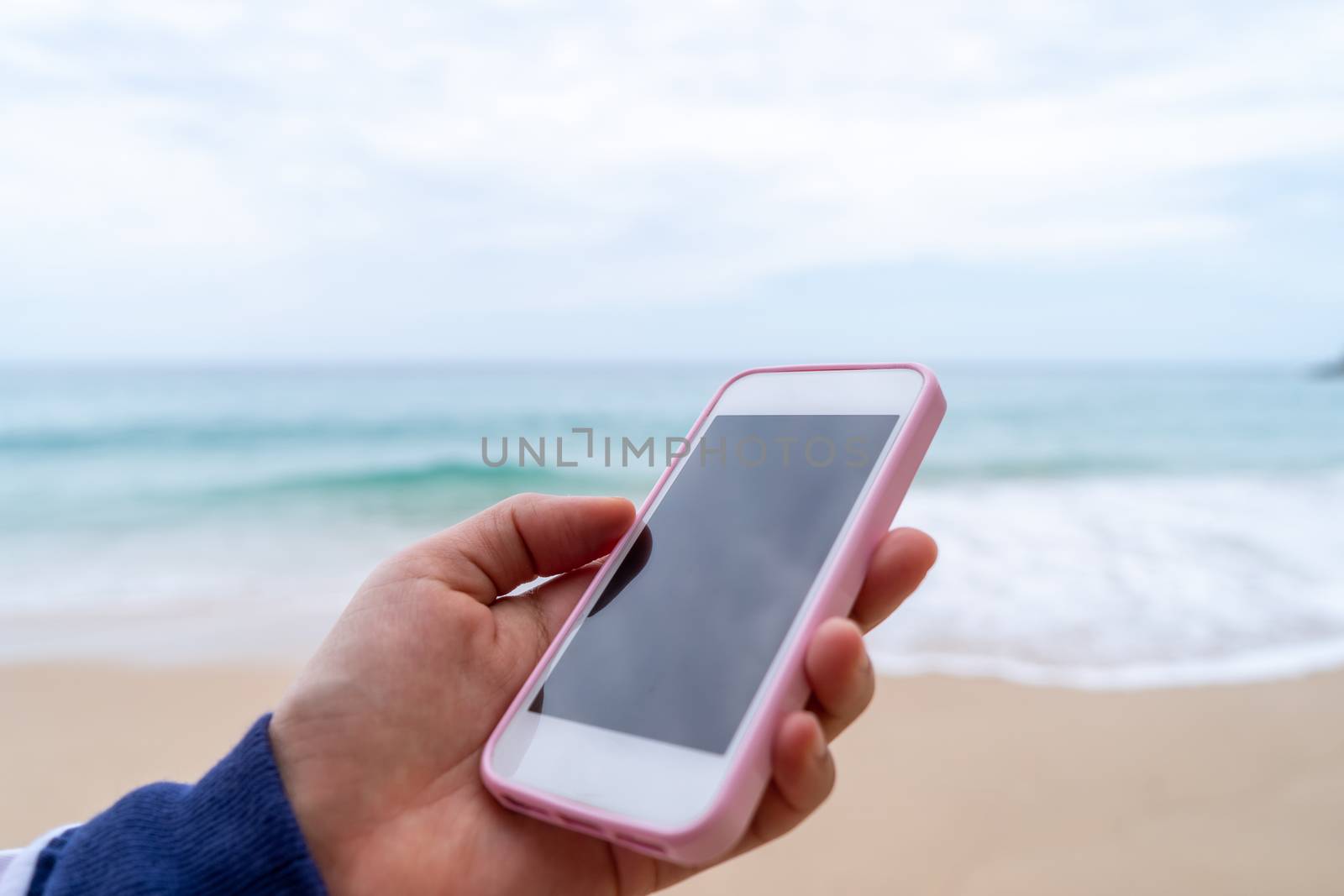 Woman using smartphone to work study in vacation day at beach background. by Suwant