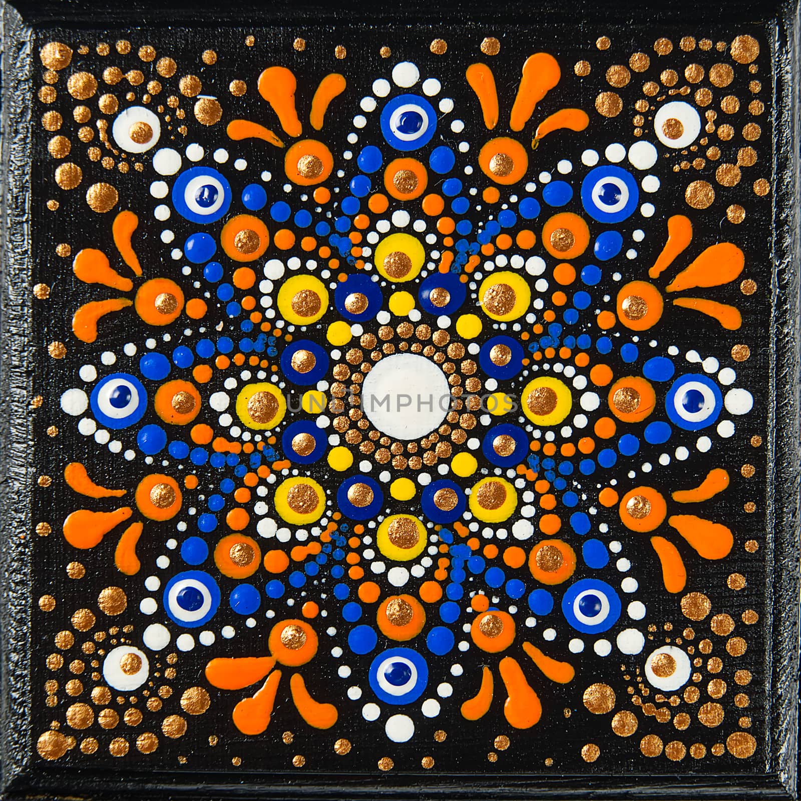Mandala dot art painting on wood tiles. Beautiful mandala hand painted by colorful dots on black wood. National patterns with acrylic paints, handwork, dot painting. Abstract dotted background. by PhotoTime