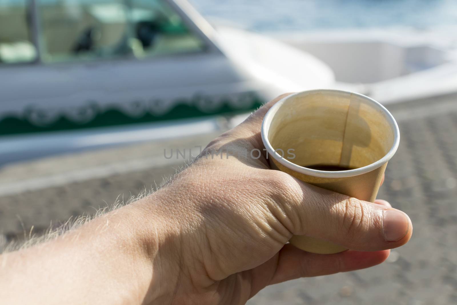 Smallest coffee in the world in Malé in the Maldives. Man holds coffee mug in hand.