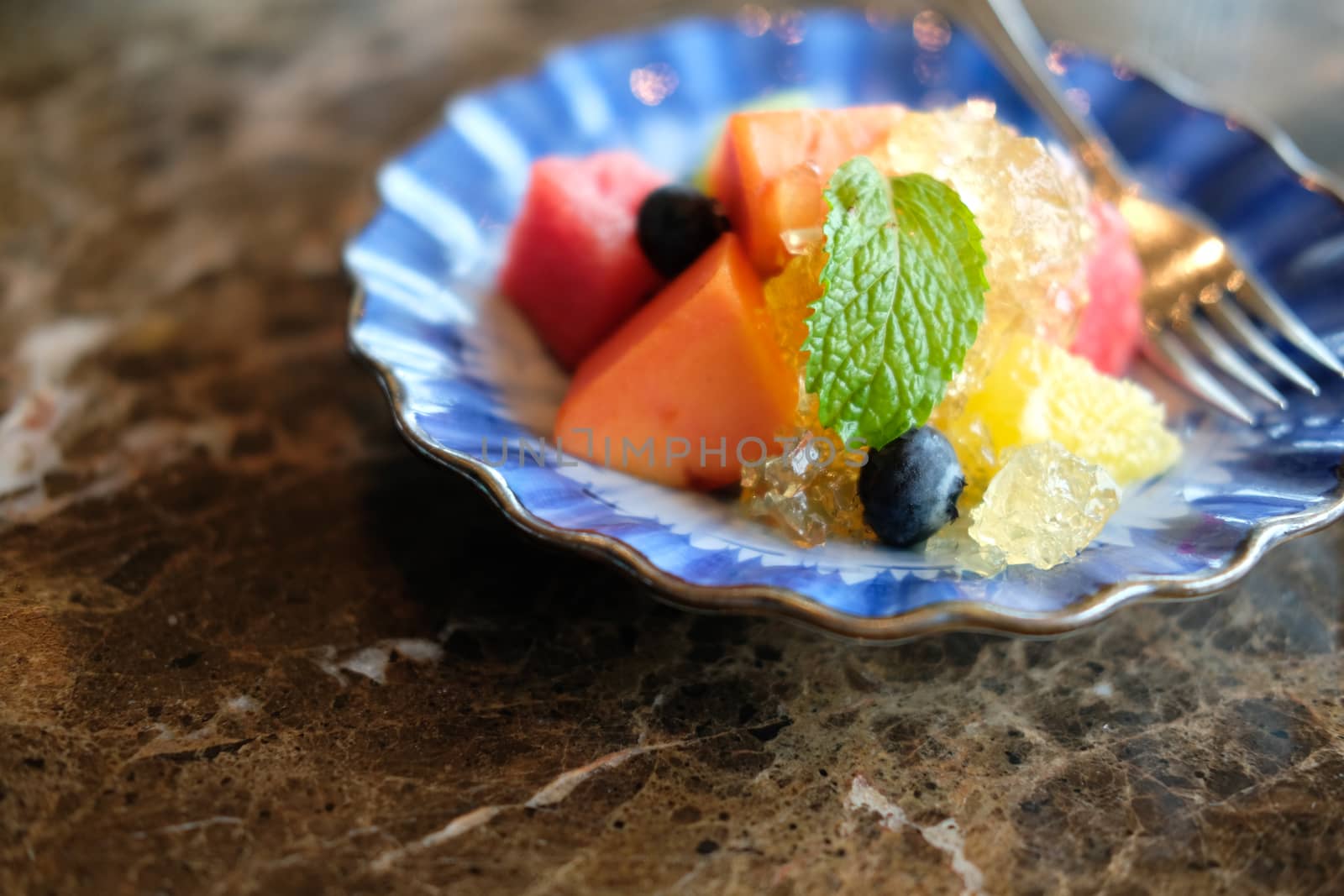 mixed fruit papaya kiwi blueberry watermelon orange in blue dish