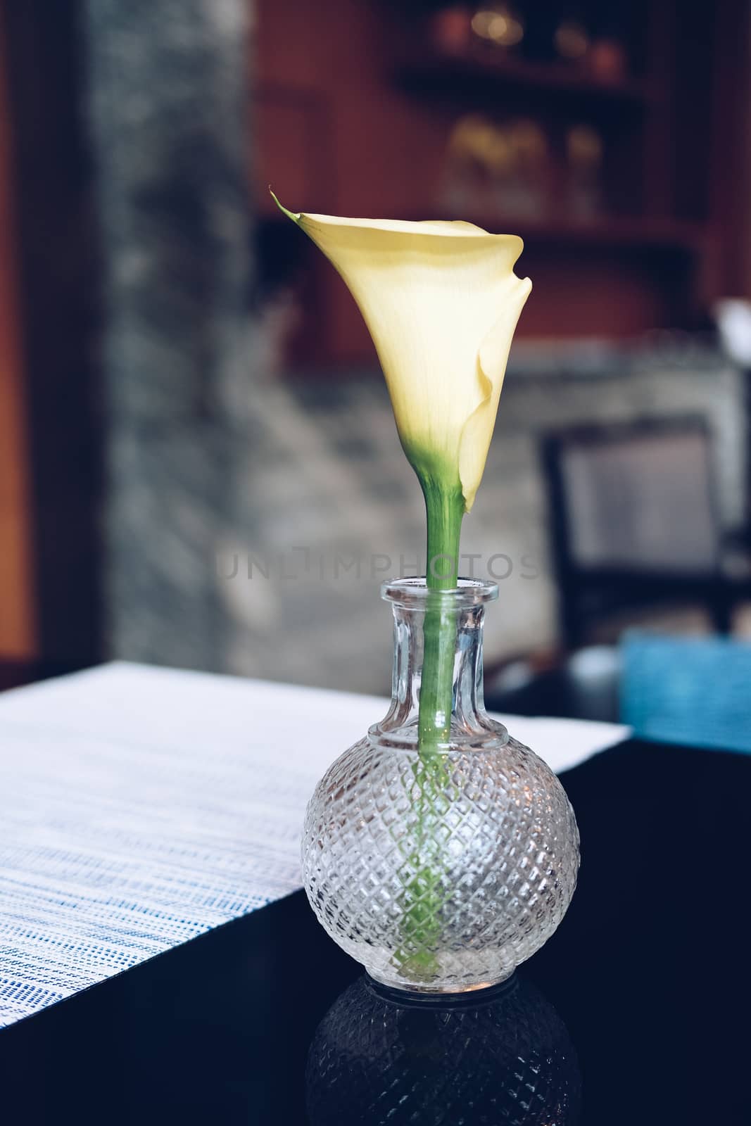 yellow flower in glass vase on restaurant table