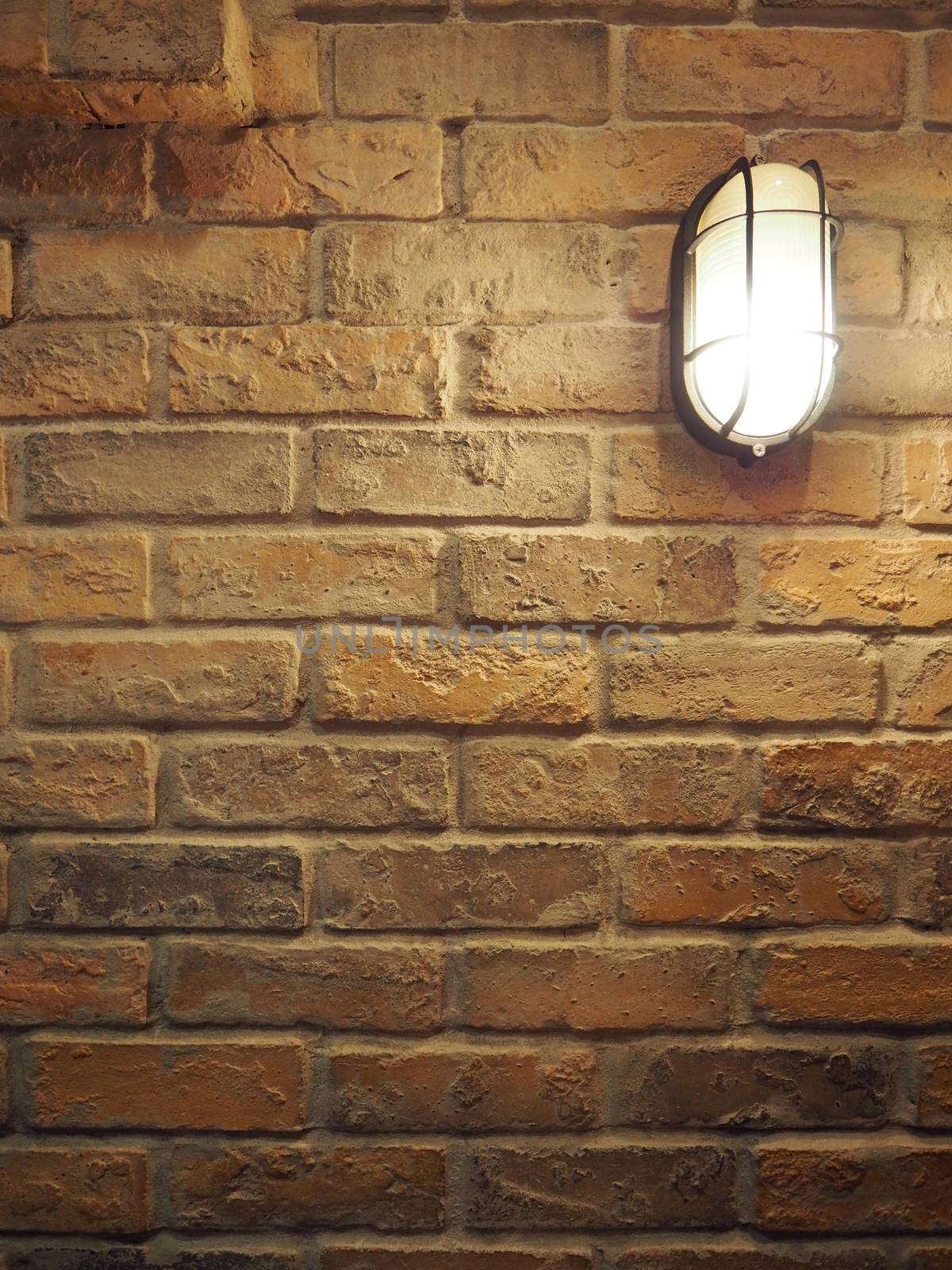 Brick wall old dirty texture background and hanging lamp. by gnepphoto