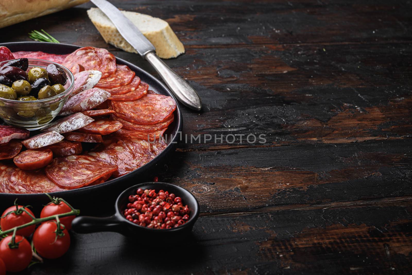 Spanish cold meat plate, chorizo, fuet, lomo,longaniza and salchichon on wooden table with copy space.