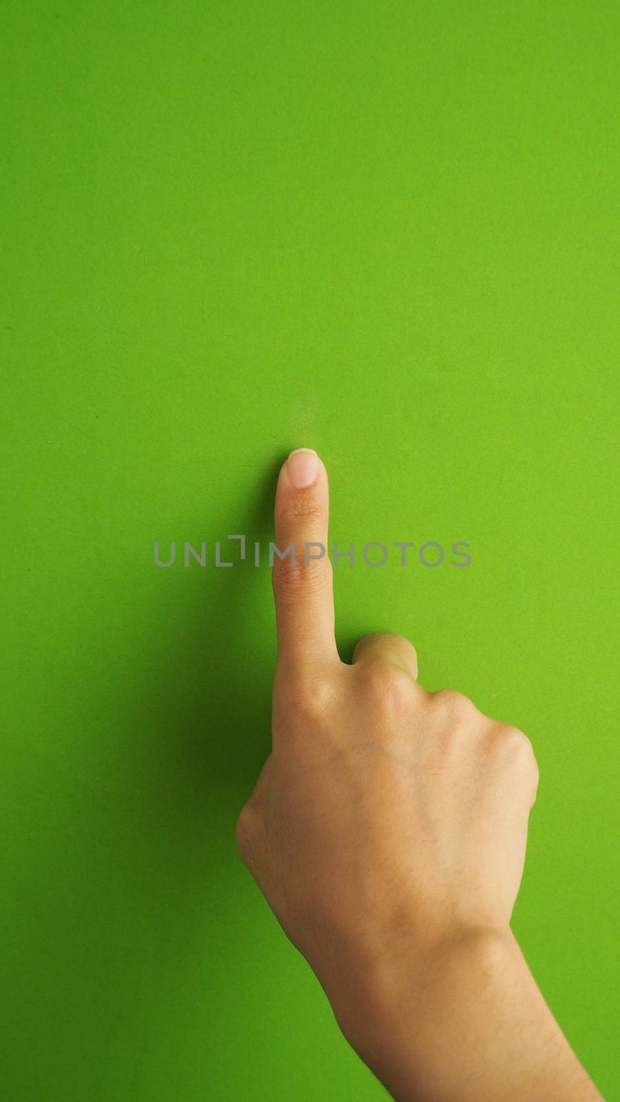 Human finger touching or pointing on green screen. by gnepphoto