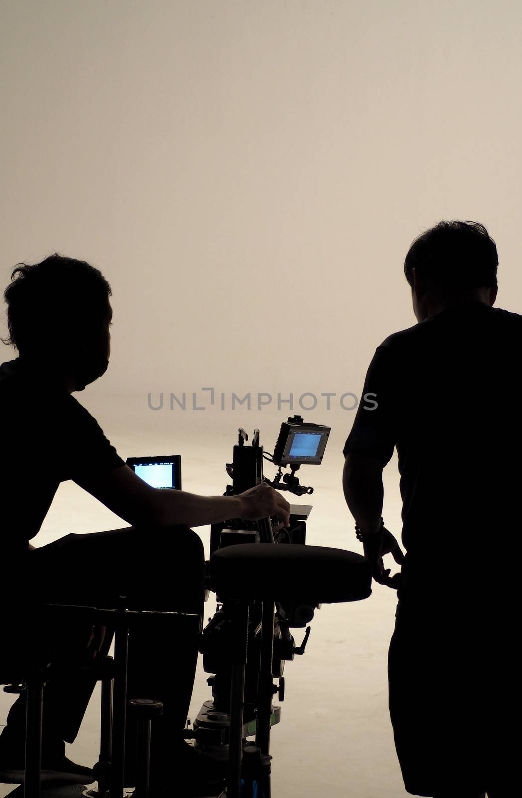 Behind the scenes of silhouette working people that making movie or tv channel content or film in big studio with camera set and production crew team.