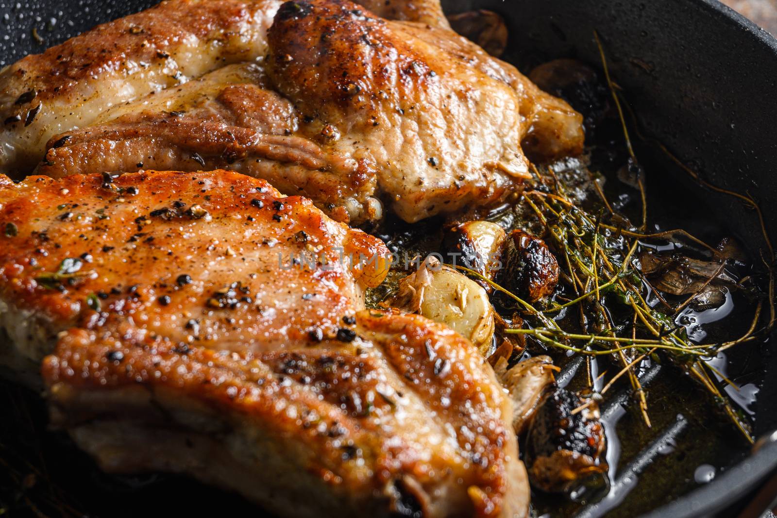 Barbecue Pork Chops on the bone with seasonings and grilled on hot skillet with smoke just from the fire close up side view