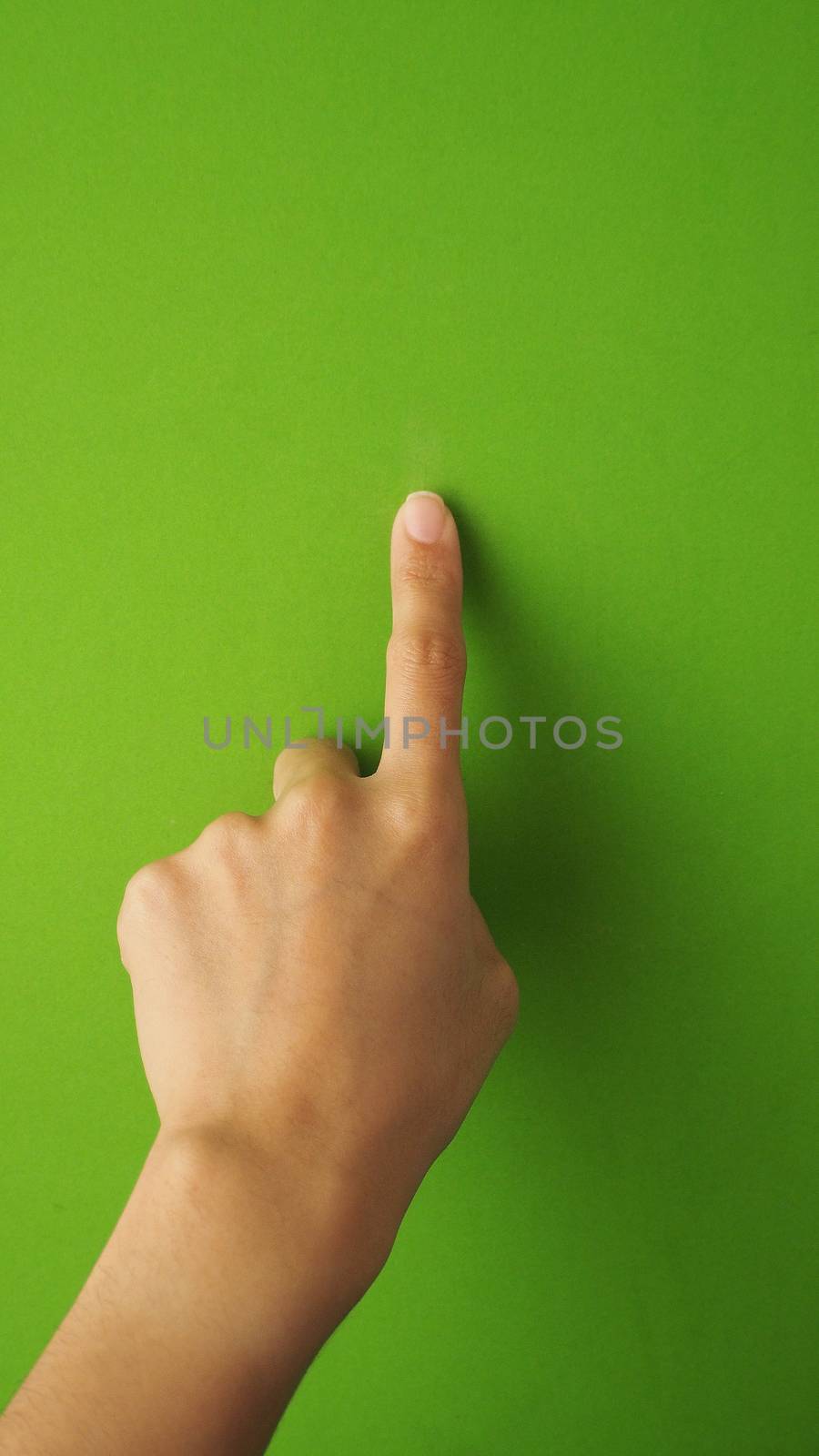 Human finger touching or pointing on green screen background and in studio.