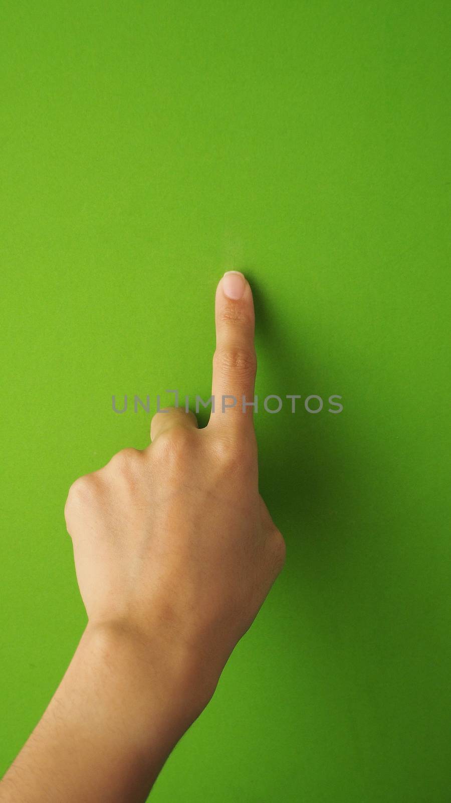 Human finger touching or pointing on green screen. by gnepphoto