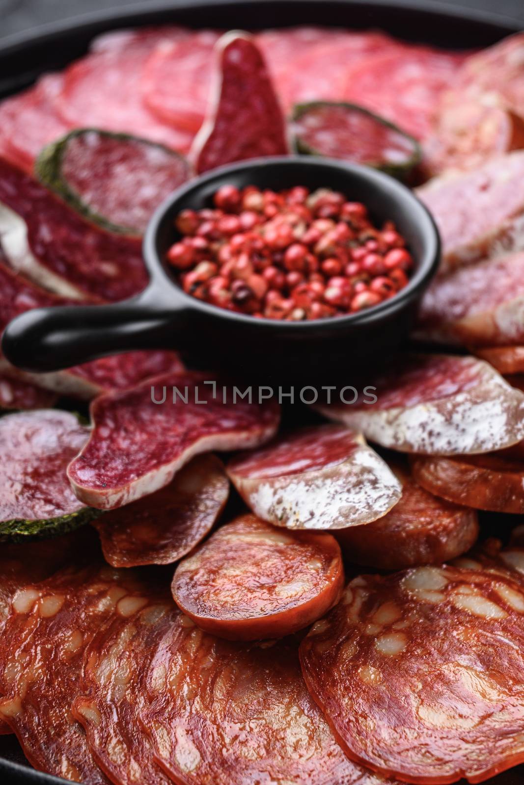 Spanish cold meat plate, chorizo, fuet, lomo,longaniza and salchichon on balck background.