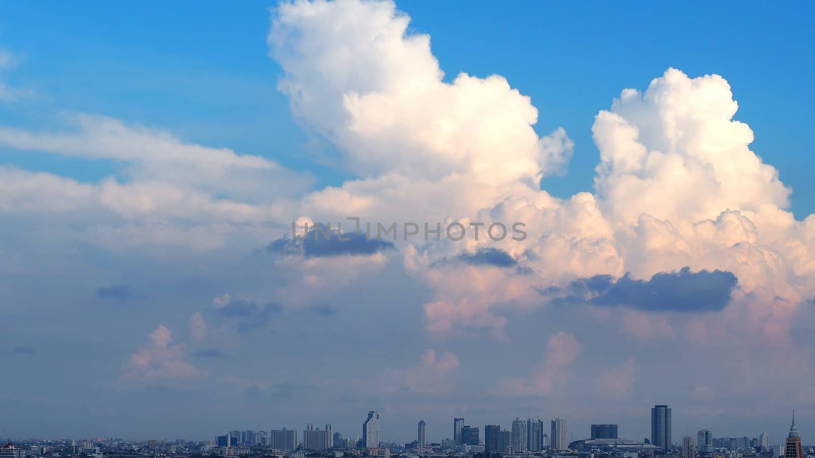 Blue sky and white clouds and landscape of city building in evening time.