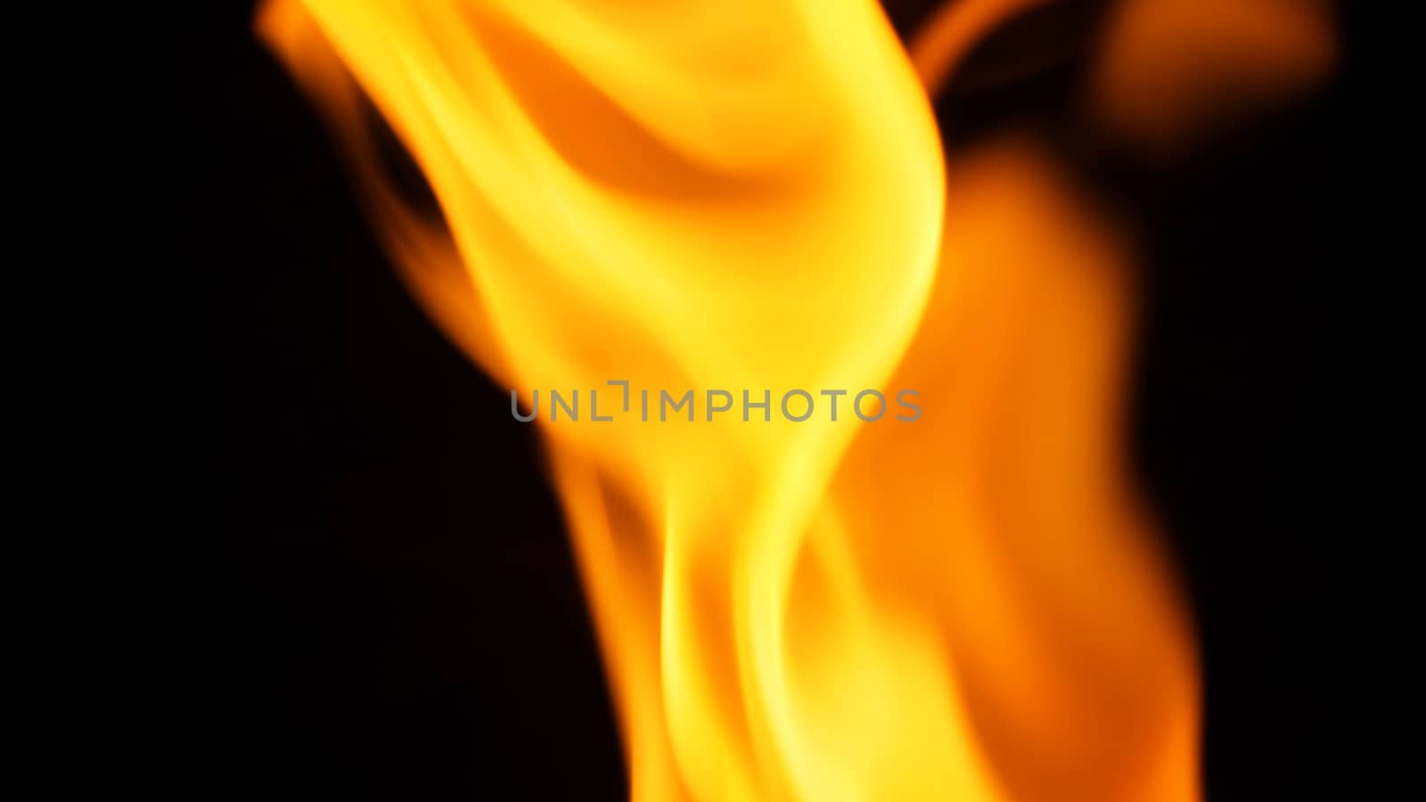 Blurred hot danger fire blazing and yellow color and black background.