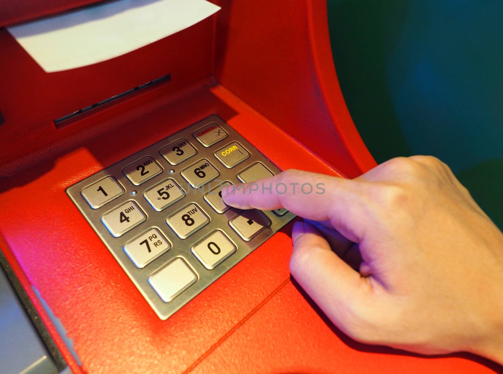 ATM machine red color and finger hand close-up. by gnepphoto