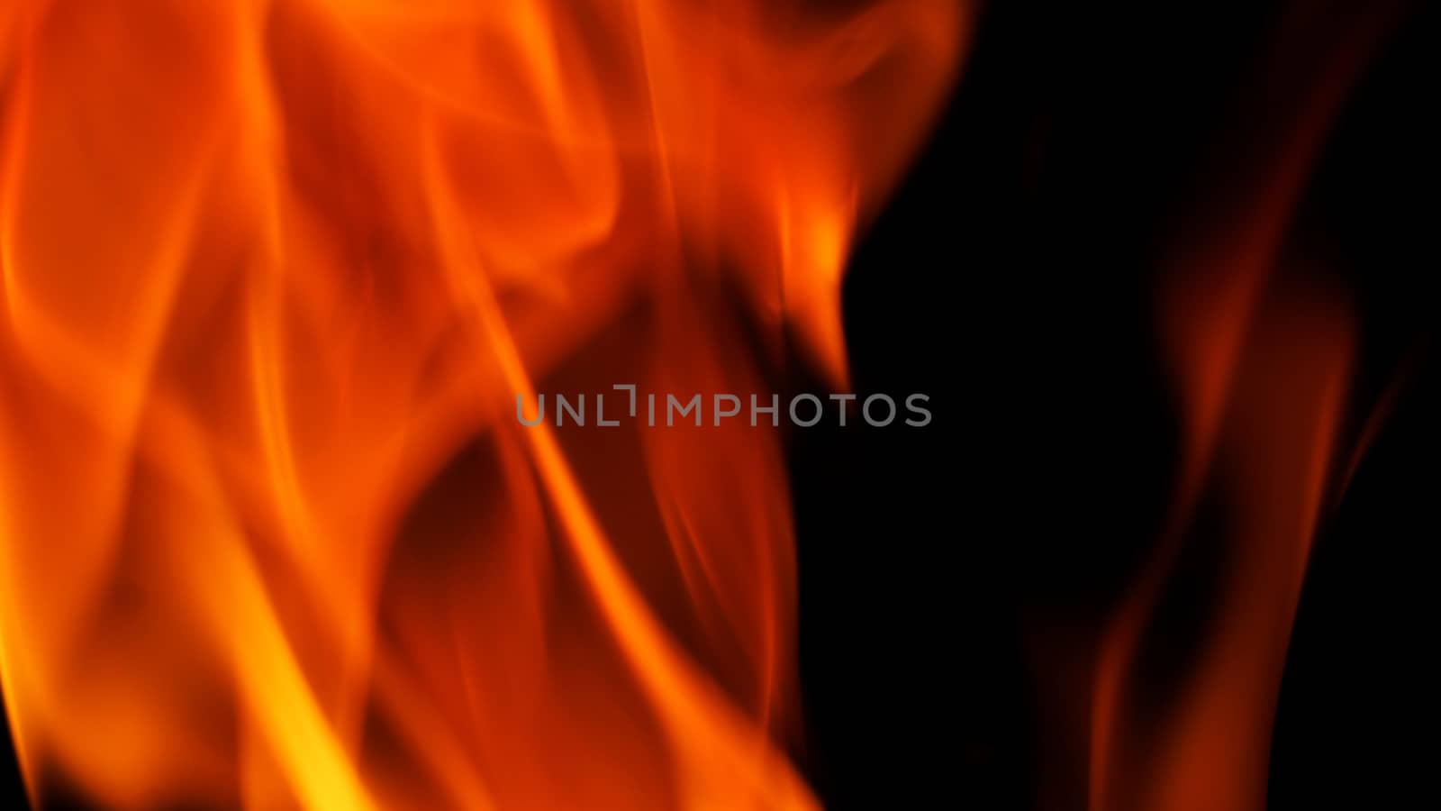 Blurred hot danger fire blazing and yellow color and black background.