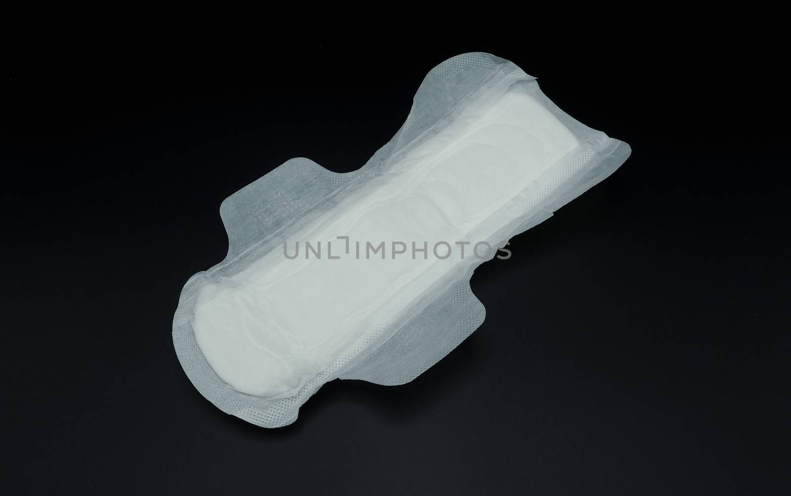 White clean hygiene sanitary napkin which soft and comfortable gently to skin on black background.