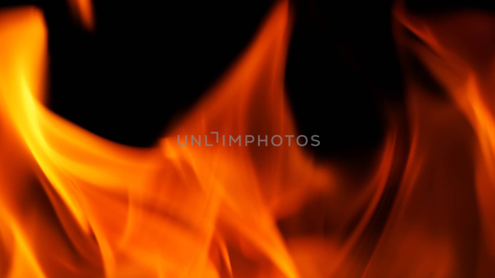 Blurred hot danger fire blazing and yellow color and black background.