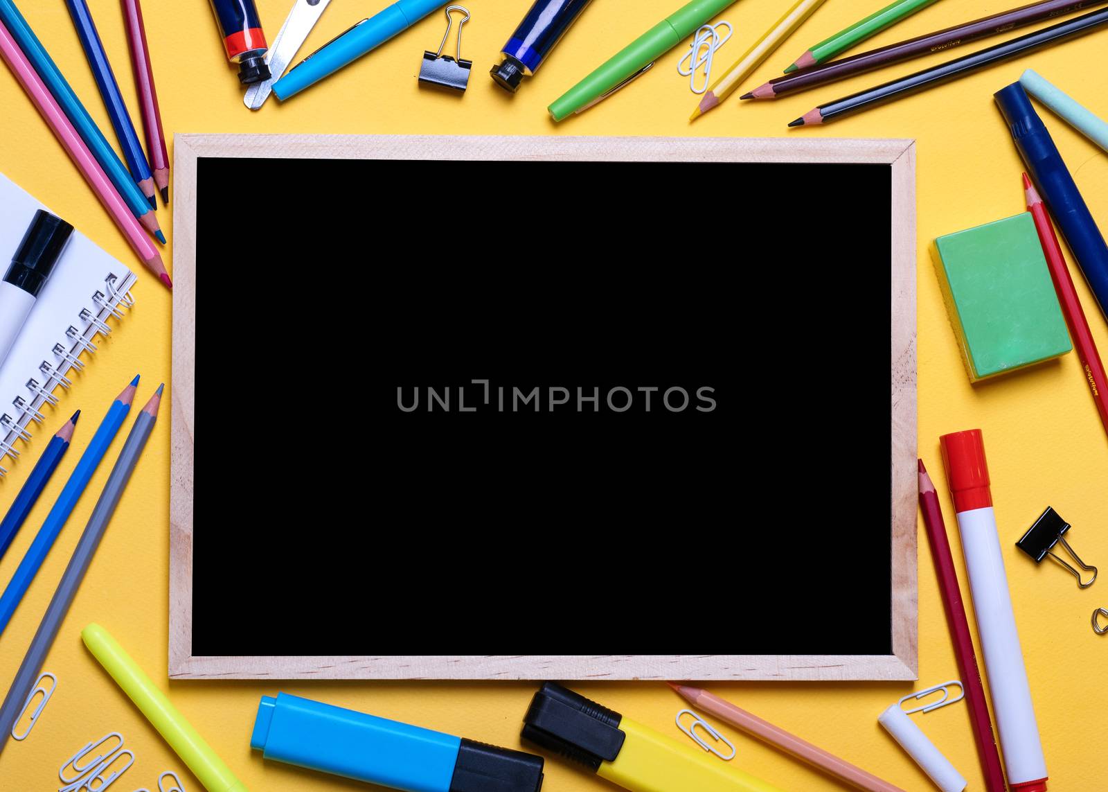 Mockup of Black board, pencils, highlighters, chalks on yellow background