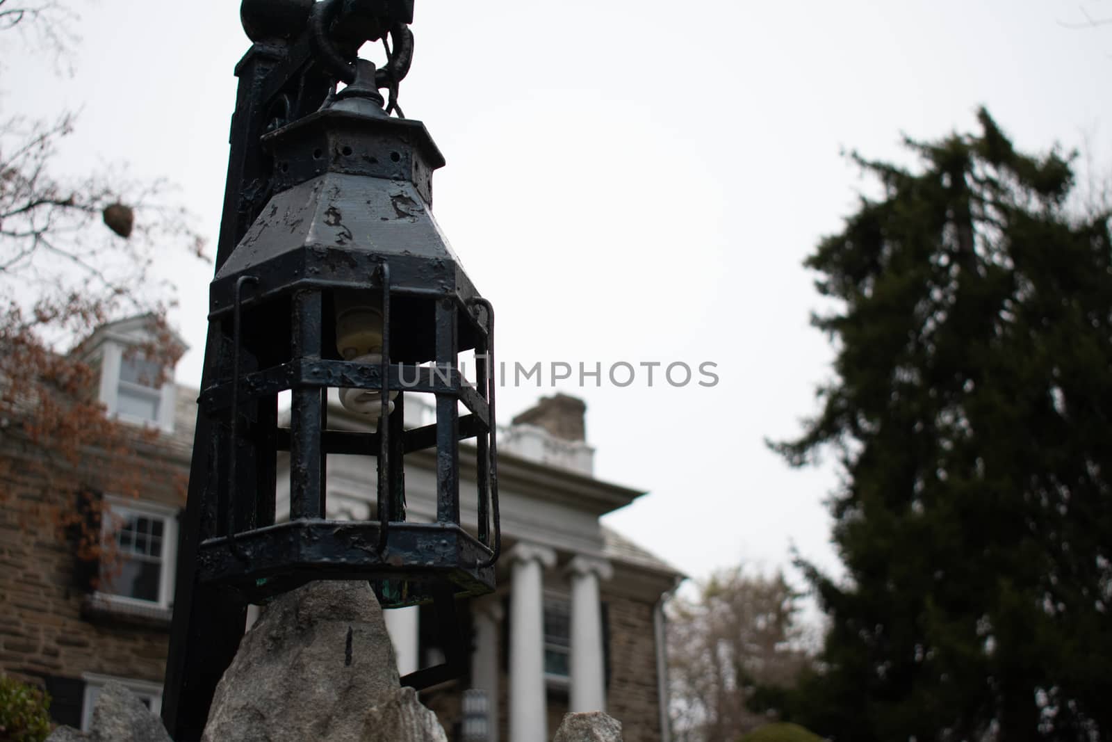 A Medieval Hanging Light in Front of a Cobblestone Mansion