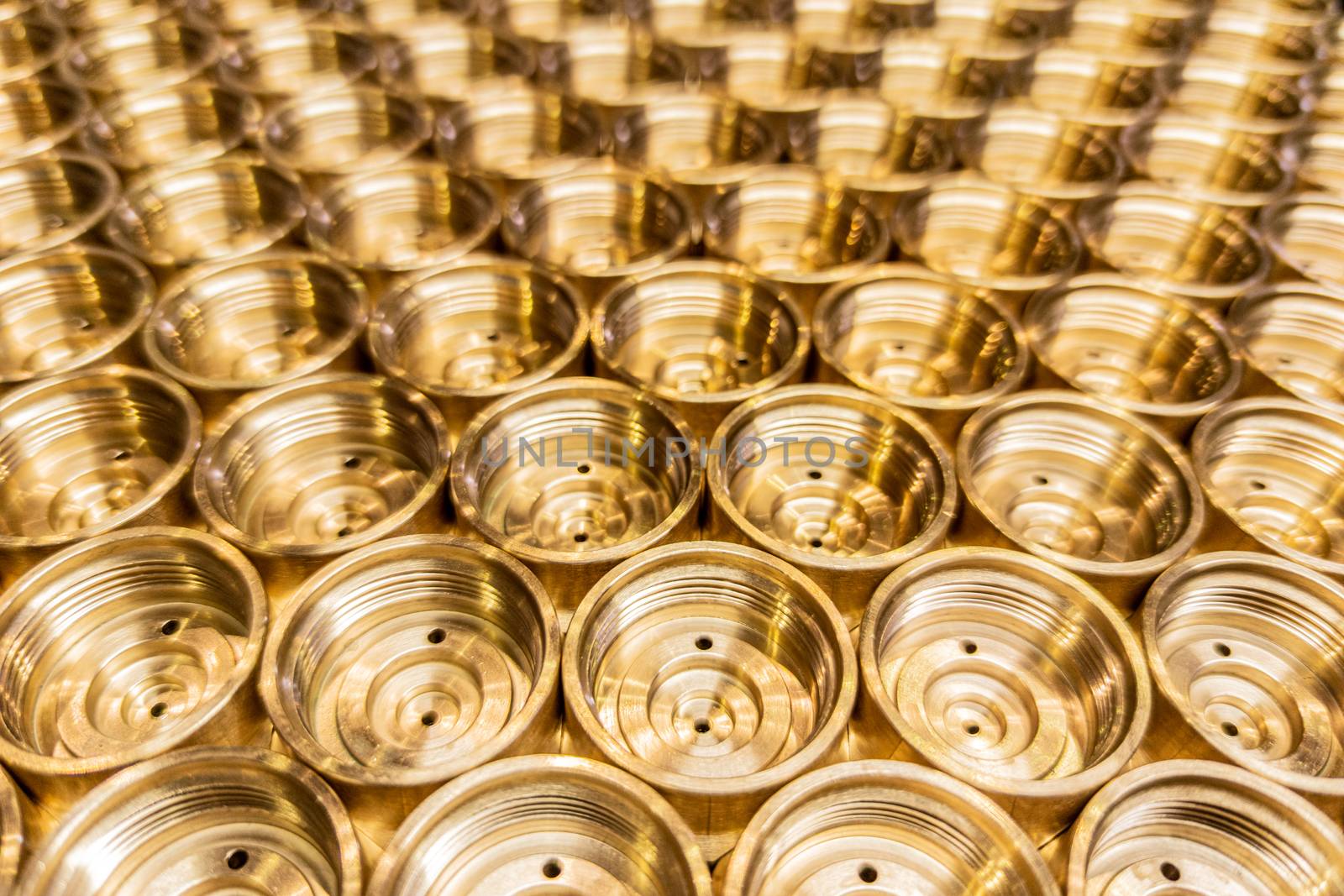 an abstract perspective industrial close-up background of shiny brass metal threaded hexagonal fitting parts.