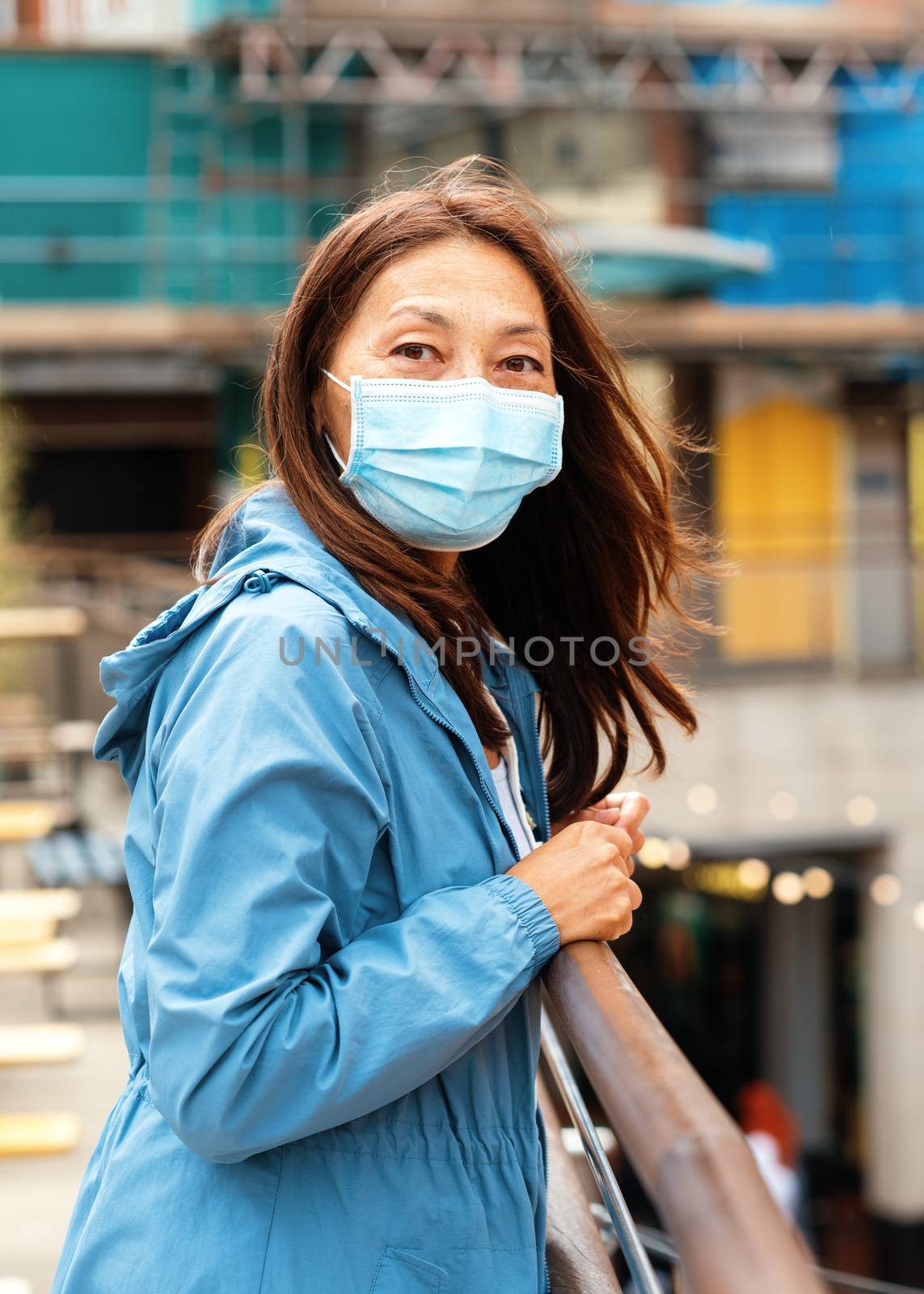 Asian woman wearing a face mask walking around city and shopping by Iryna_Melnyk