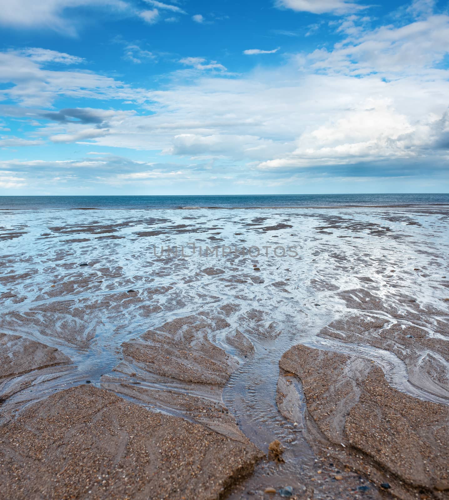 Sand beach, sea and cloudy blue sky in England in day