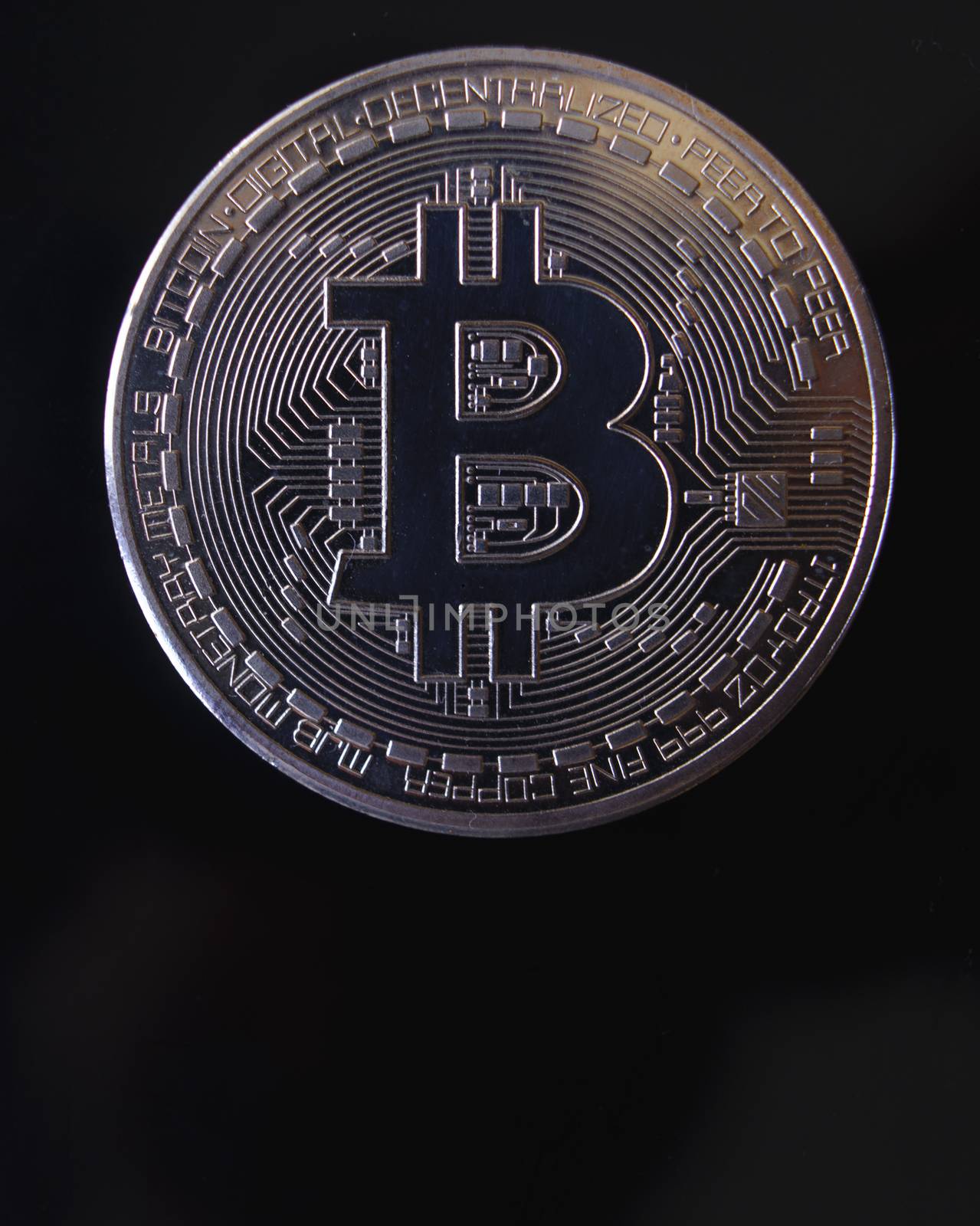 Silver souvenir coin Bitcoin on a black background.