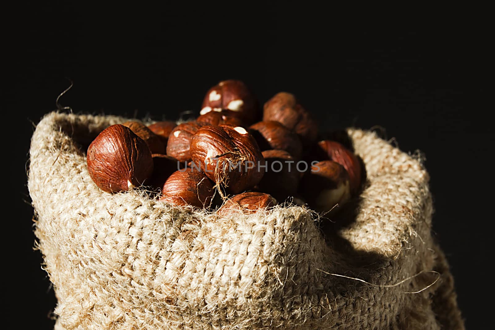 Unpeeled hazelnuts in a bag close up