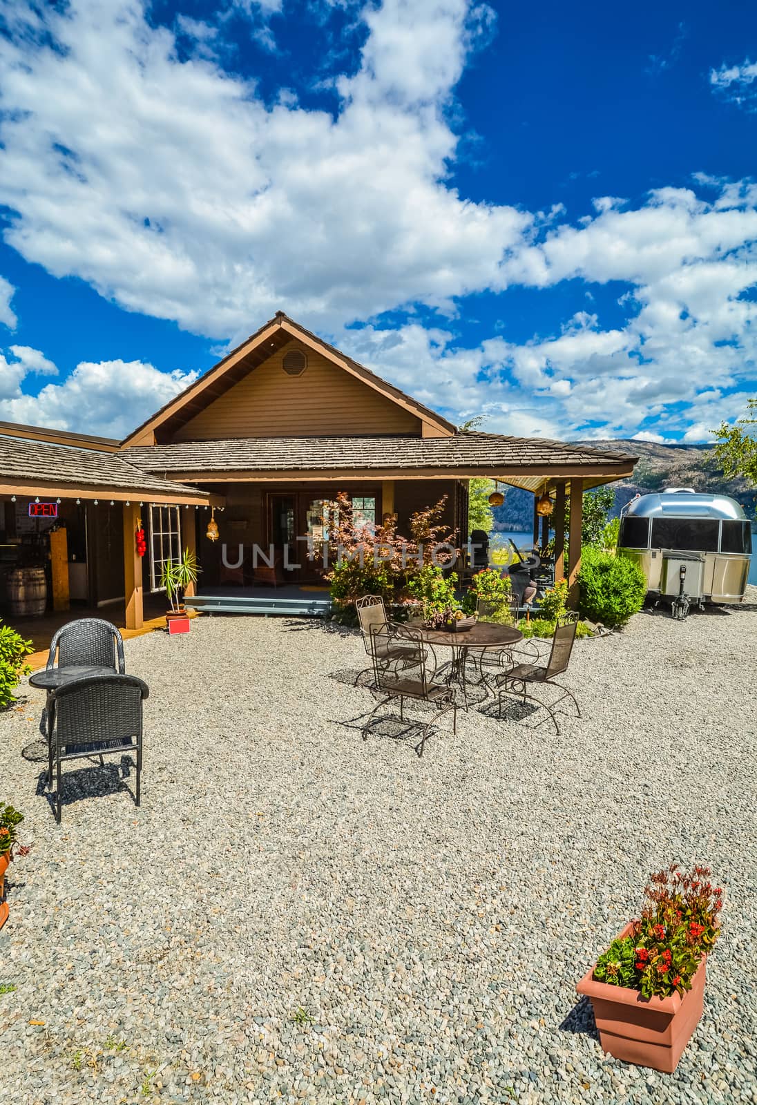 Outdoor cafe on road side close to waterfront of Okanagan lake with view to the mountains