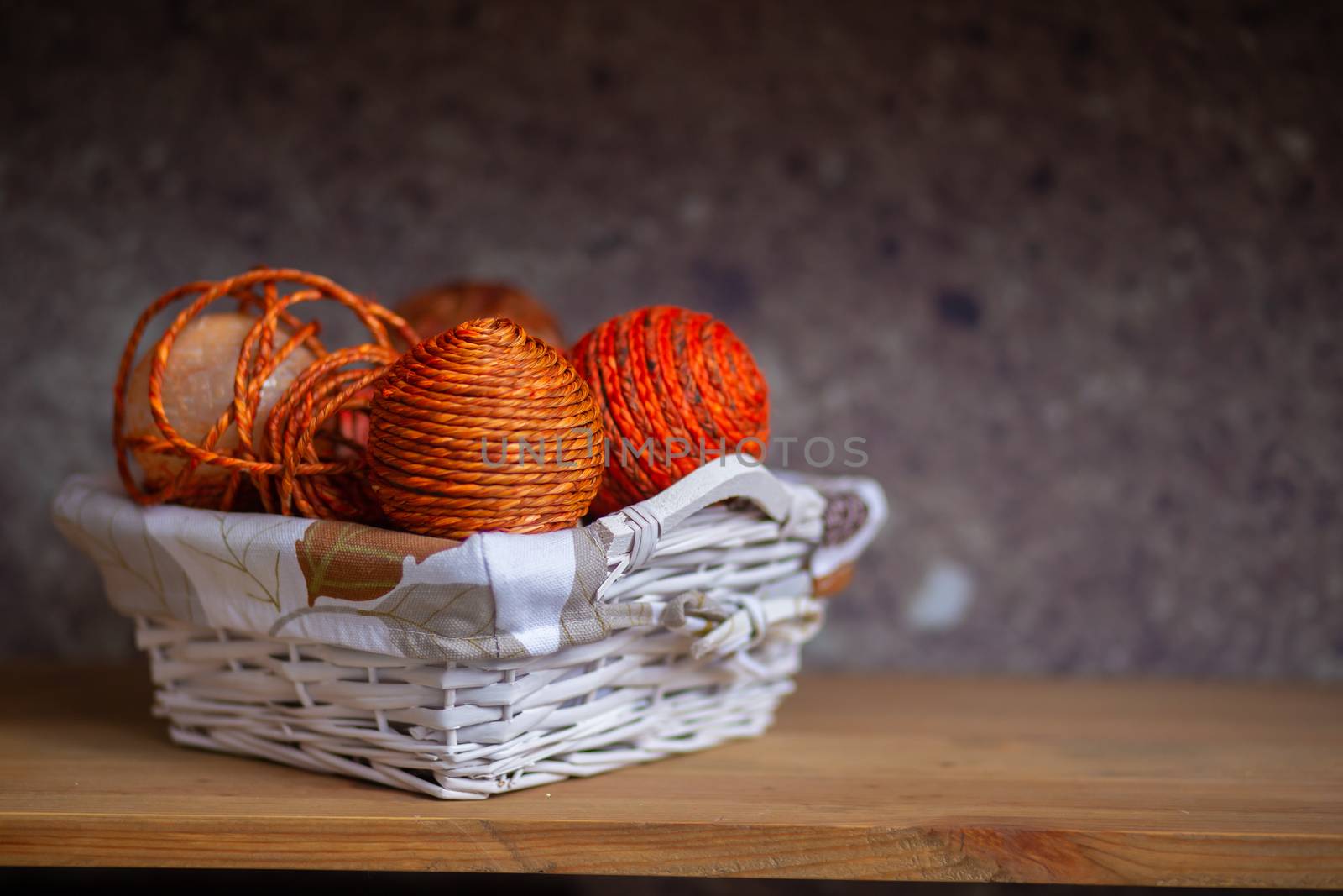 Wicker basket with orange balls of thread or rope folded into it