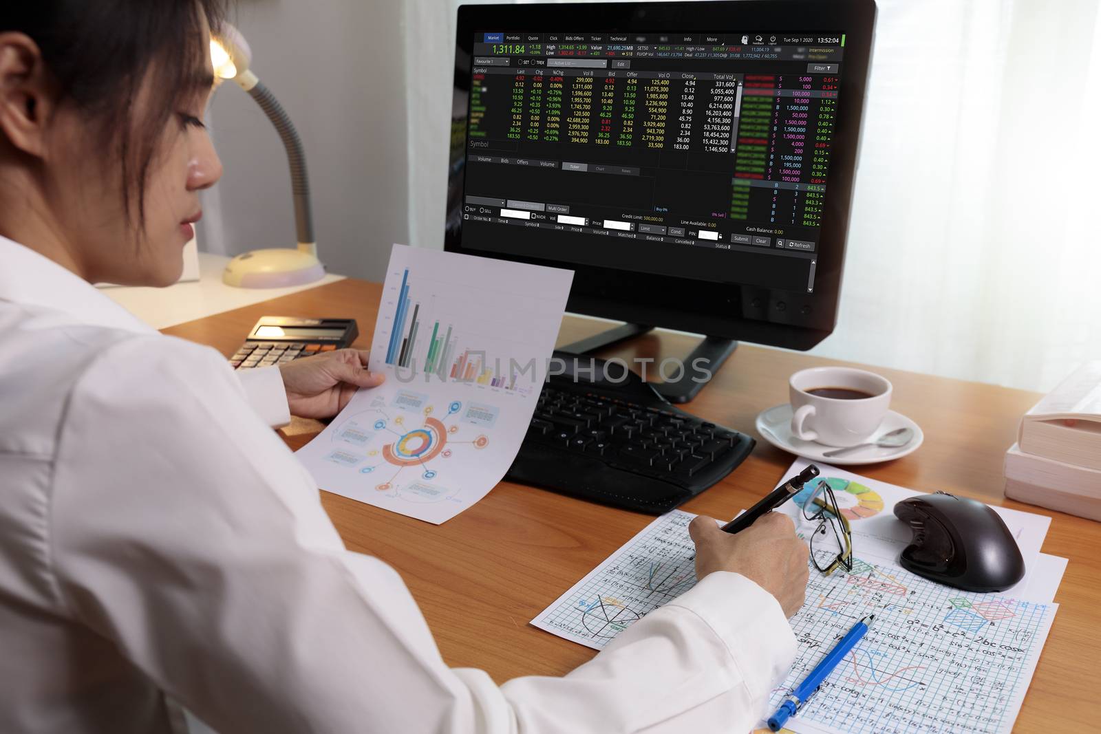 Business woman working in office with computer holding chart report paper and looking. business people working at home with paper and PC screen. Business and finance ,work at home concept