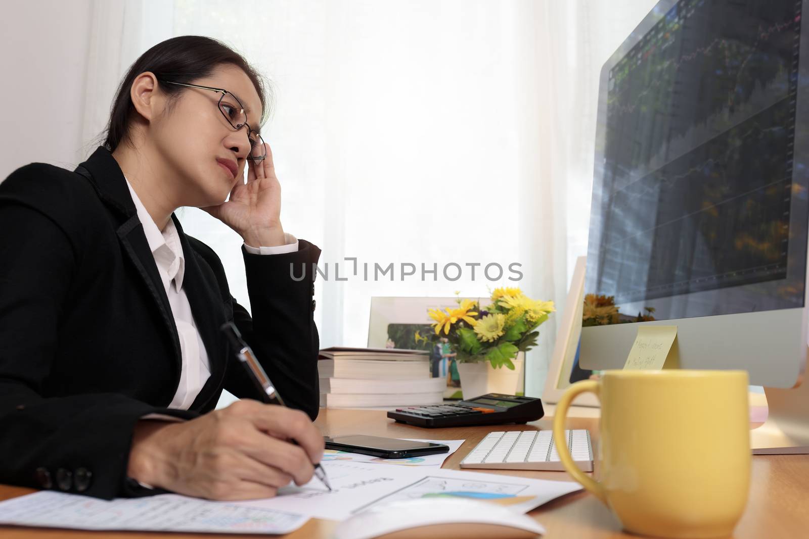 Business woman working in office with computer thinking analysis stock chart. business people working at home with PC screen. Business and finance ,work at home concept