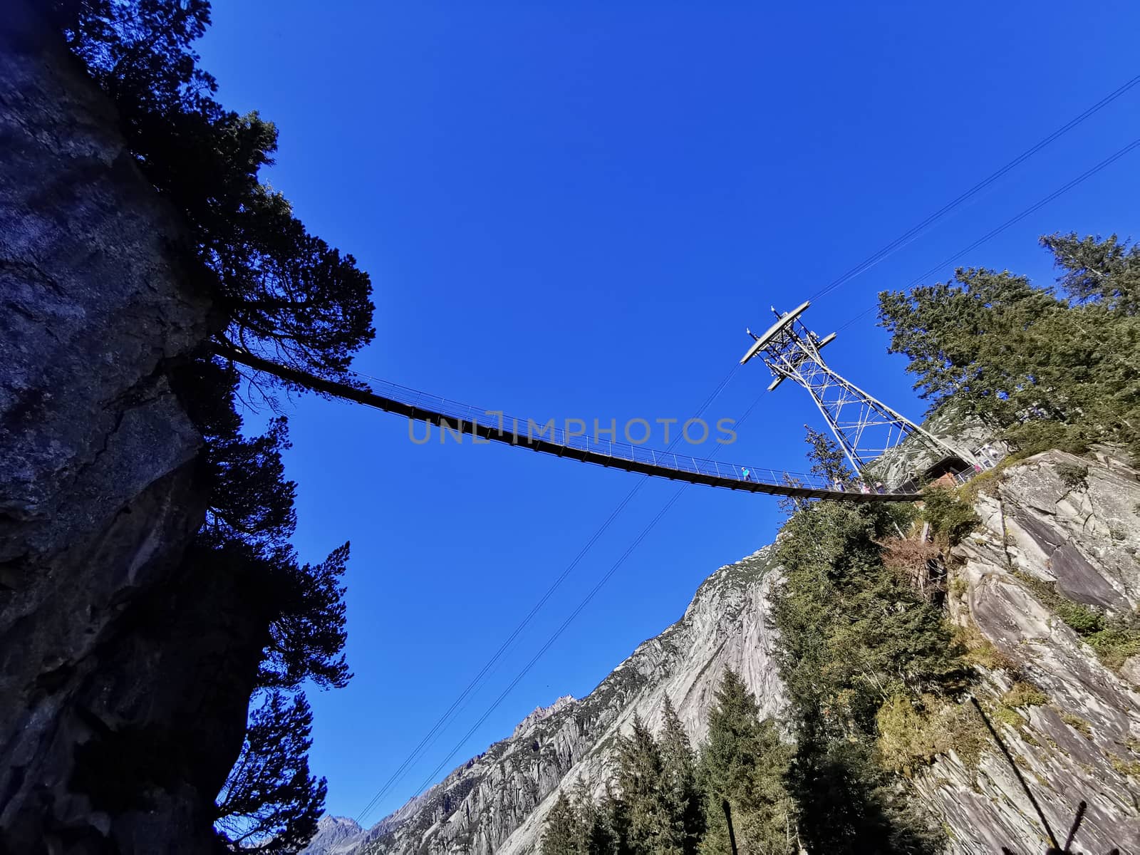 Hanging bridge over a valley. Path between rocks.