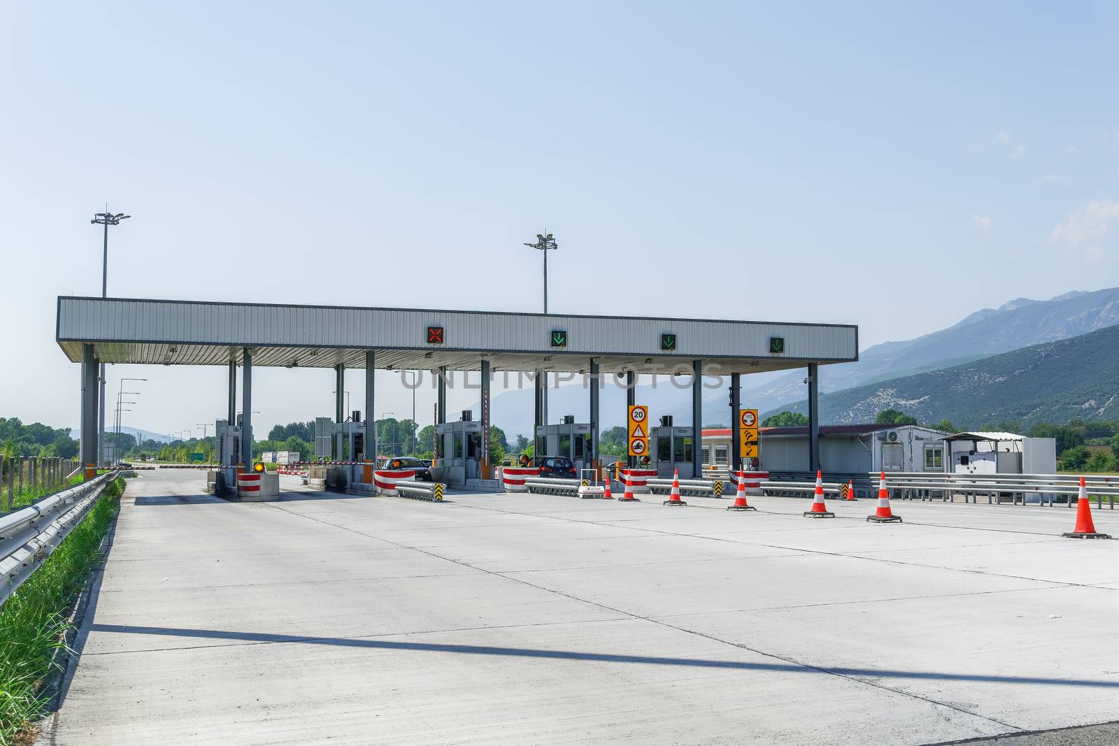 Greek roadway where car drivers pay to pass gates for Egnatia Motorway sections, with e-pass option.