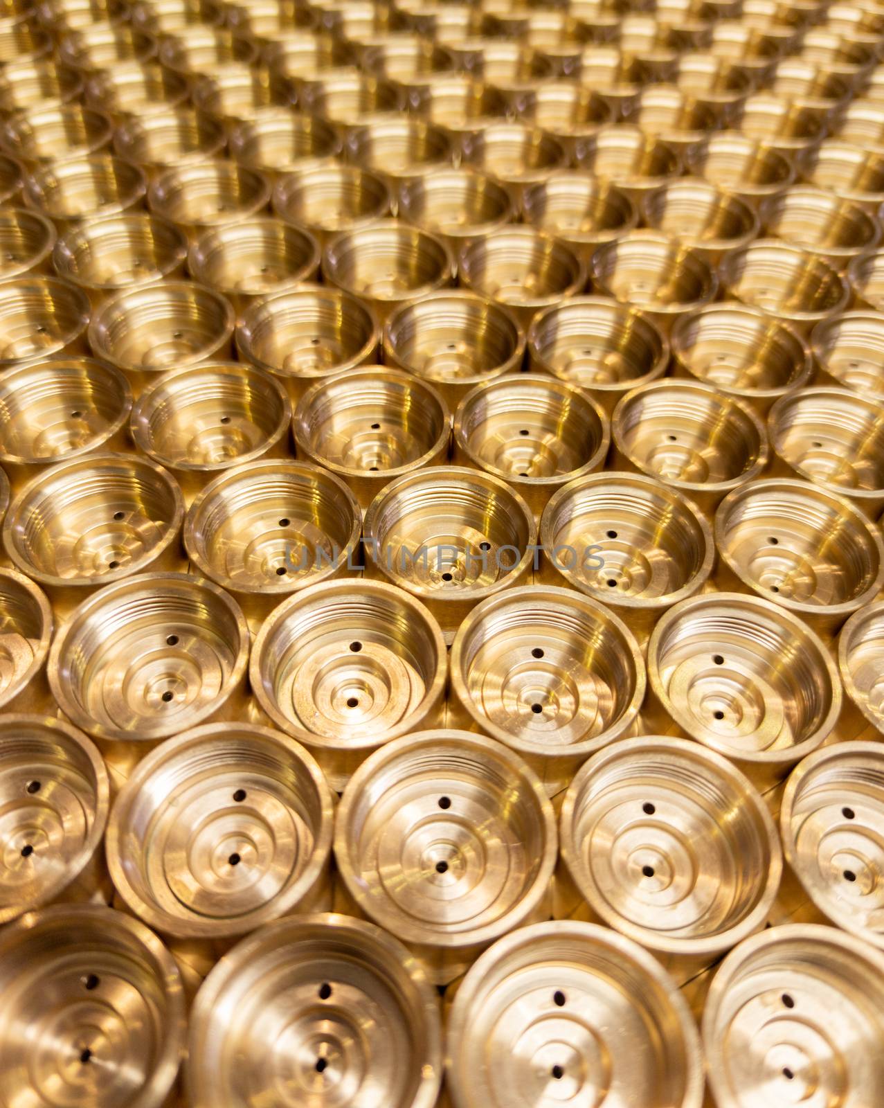 an abstract perspective industrial close-up background of shiny brass metal threaded hexagonal fitting parts.