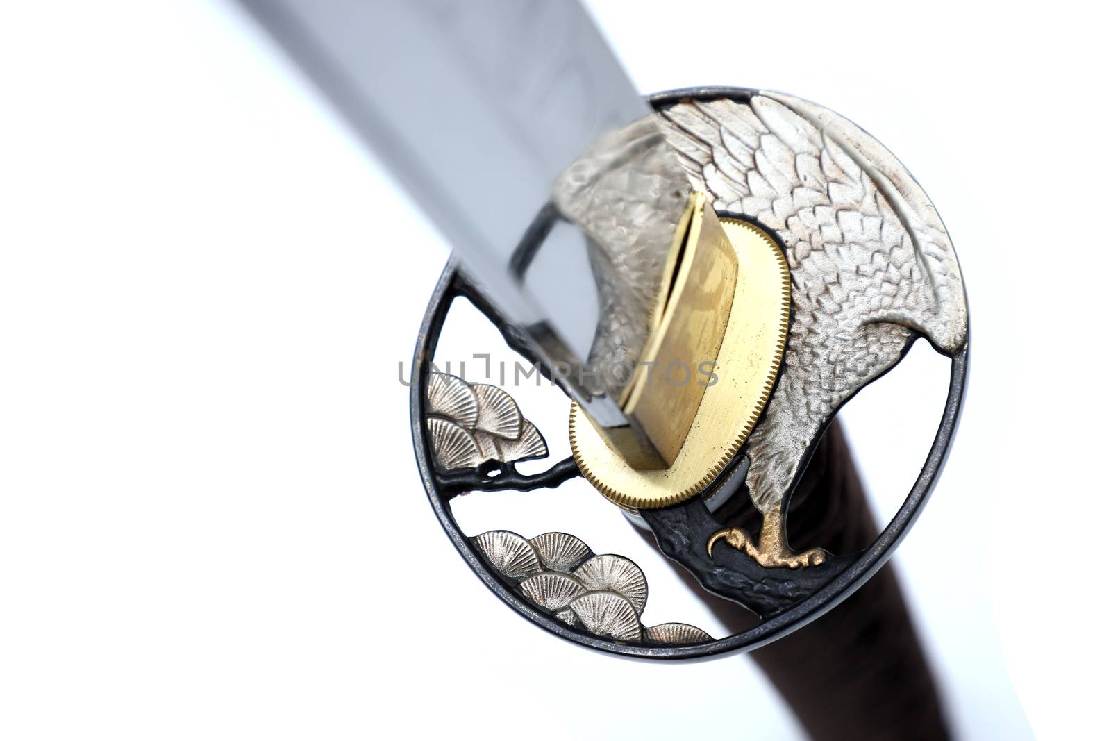 Tsuba is a hand guard of Japanese sword made of steel​  isolated in white background.  Selective focus.