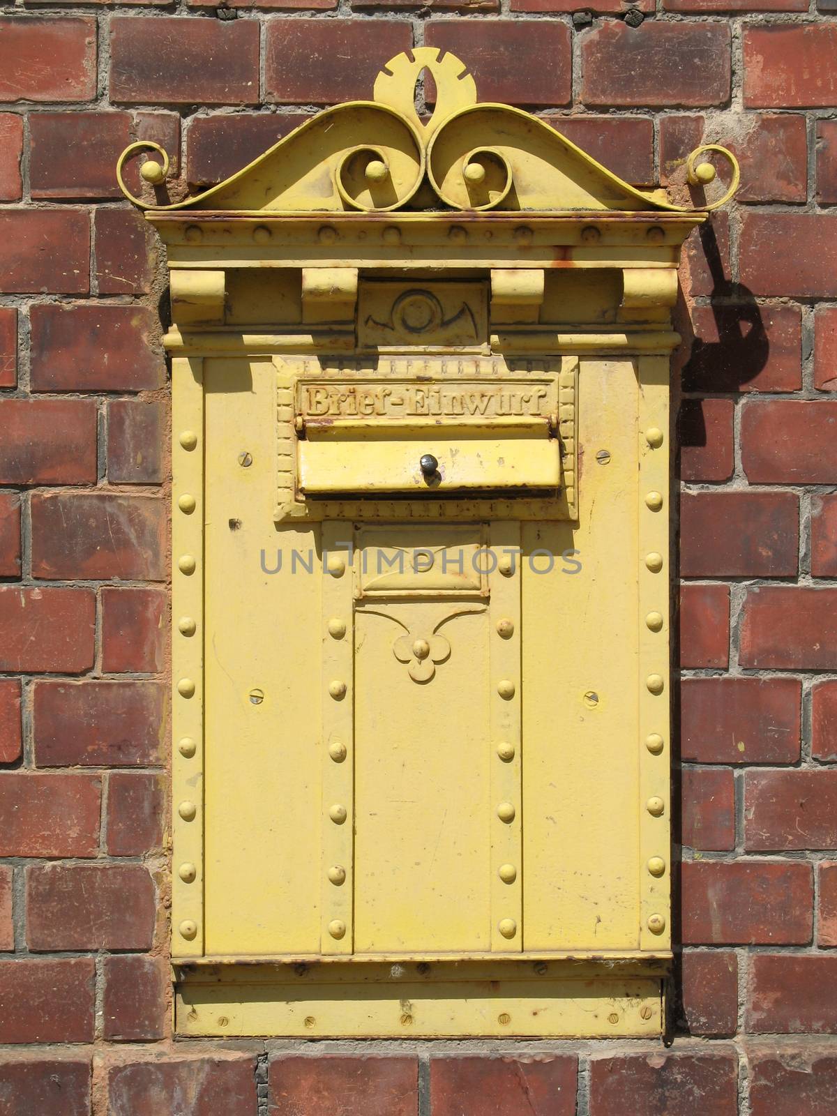Old yellow post box in Roebel, Germany.
