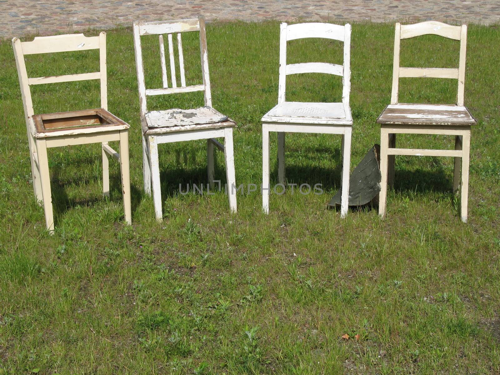 Four restoration-needy chairs that are offered by an antique dealer for sale.