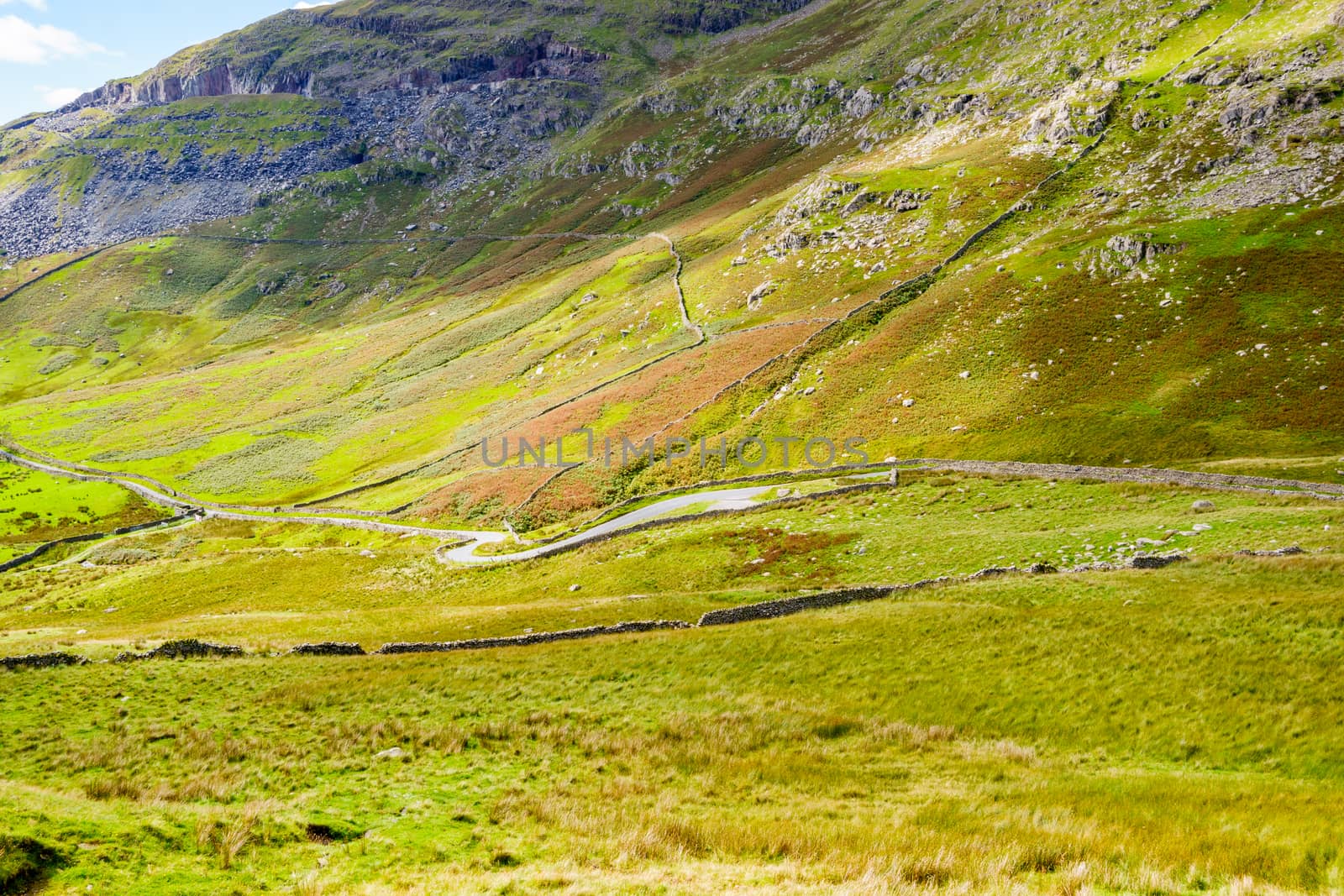 The Struggle road at Kirkstone Pass leading to Windermere lake Ambleside with Snarker Pike of Red Screes mountain on right in Lake District England