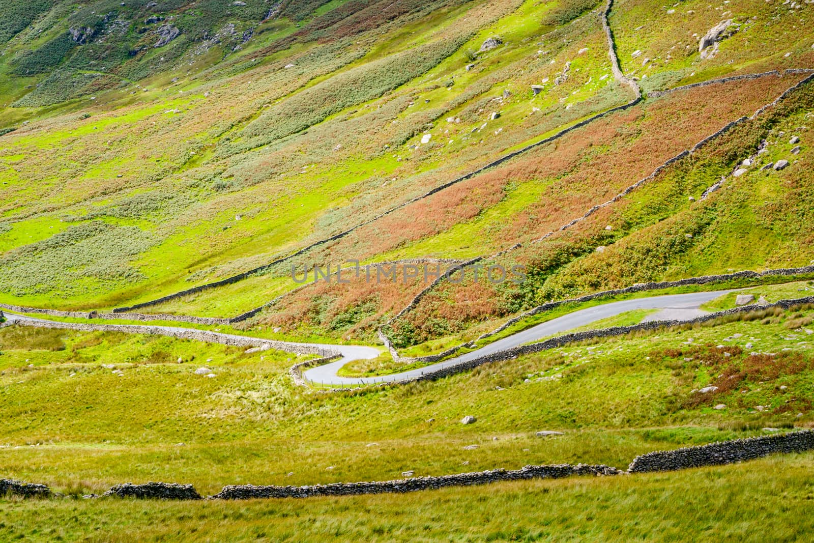 The Struggle road at Kirkstone Pass leading to Windermere lake Ambleside with Snarker Pike of Red Screes mountain on right in Lake District England