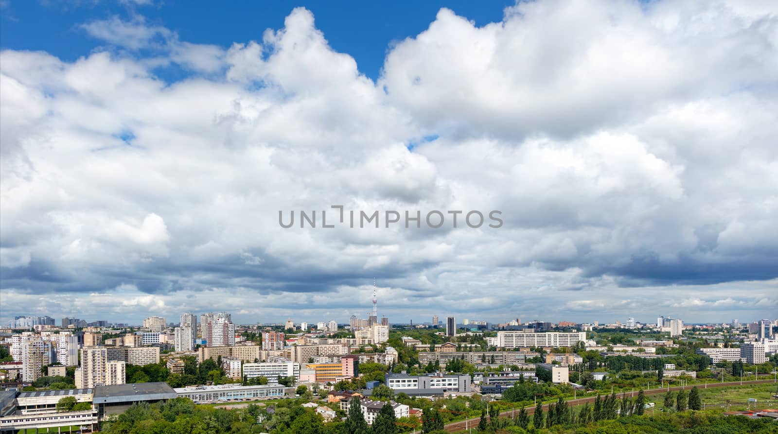 Panorama of Kyiv, with high cloudy skies over residential areas, green parks and a TV tower. by Sergii